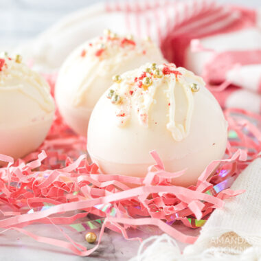 white chocolate hot cocoa bombs on pink shredded paper
