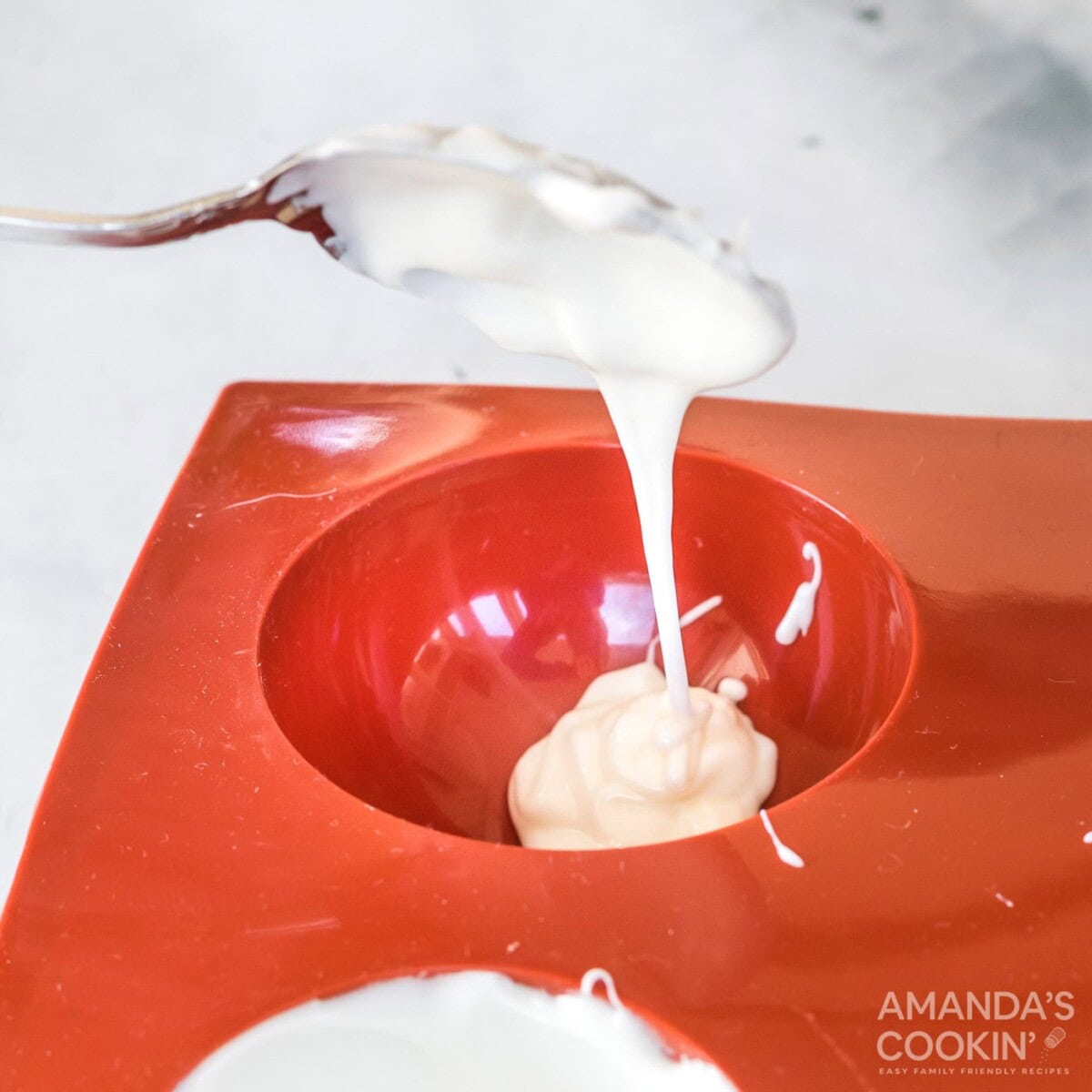 spooning white chocolate into mold