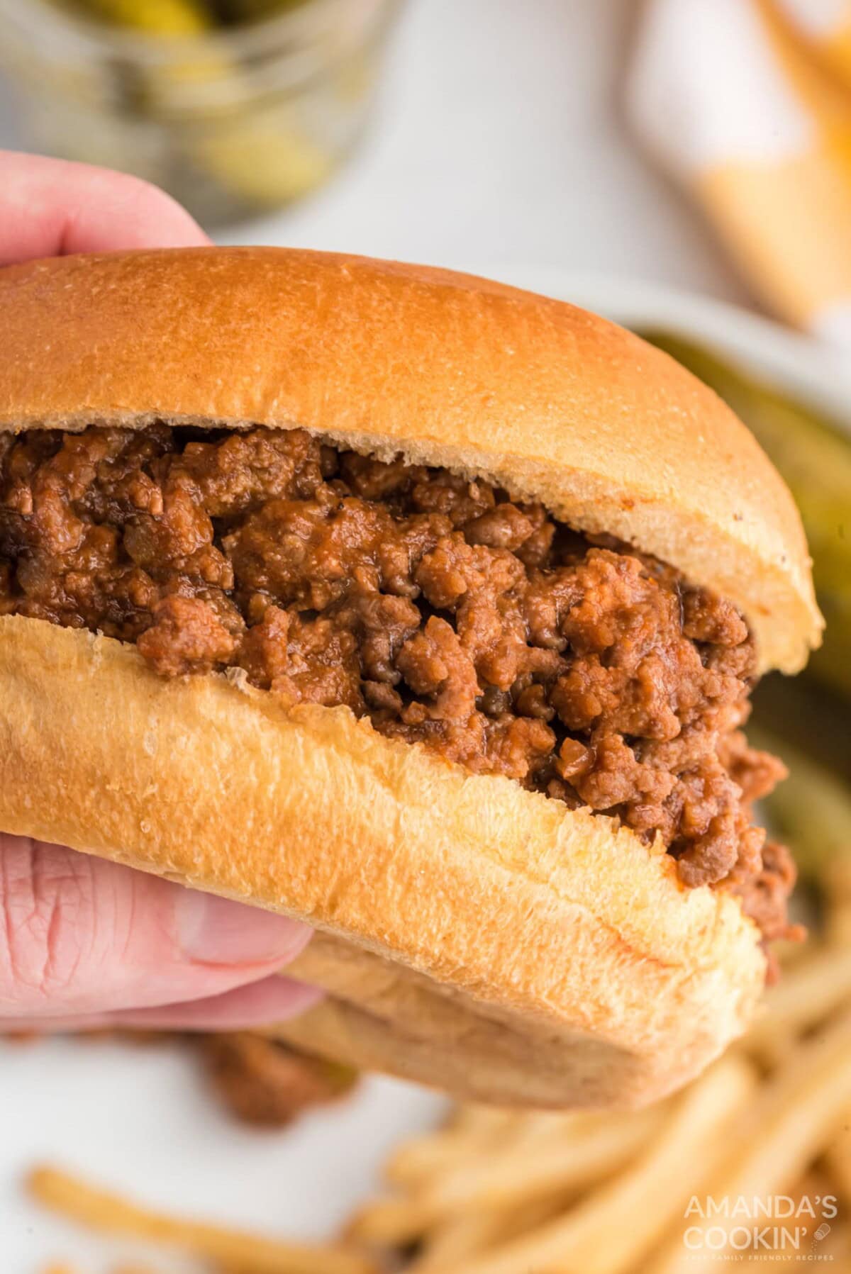 hand holding a sloppy joe sandwich