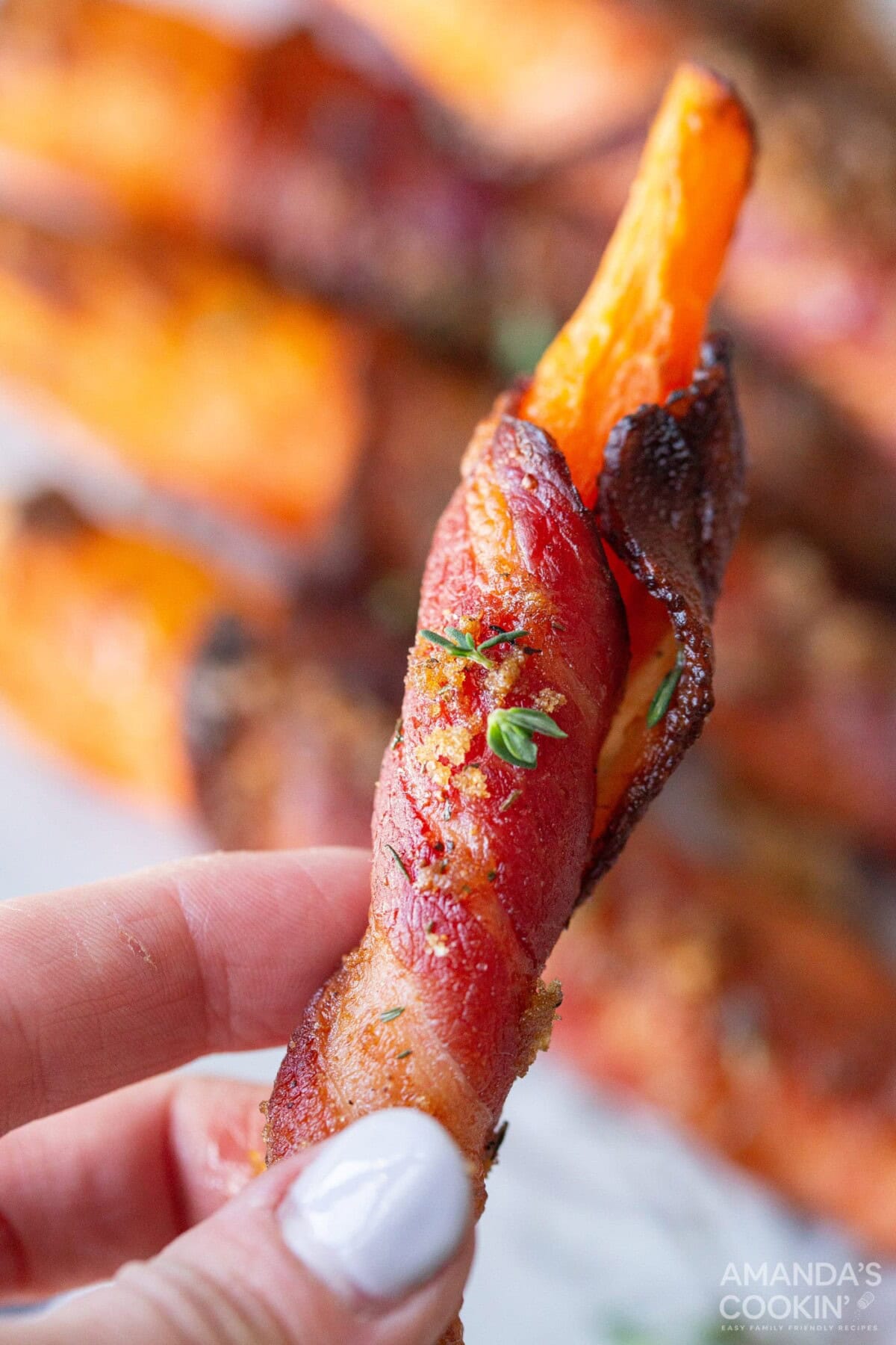 holding a bacon wrapped carrot