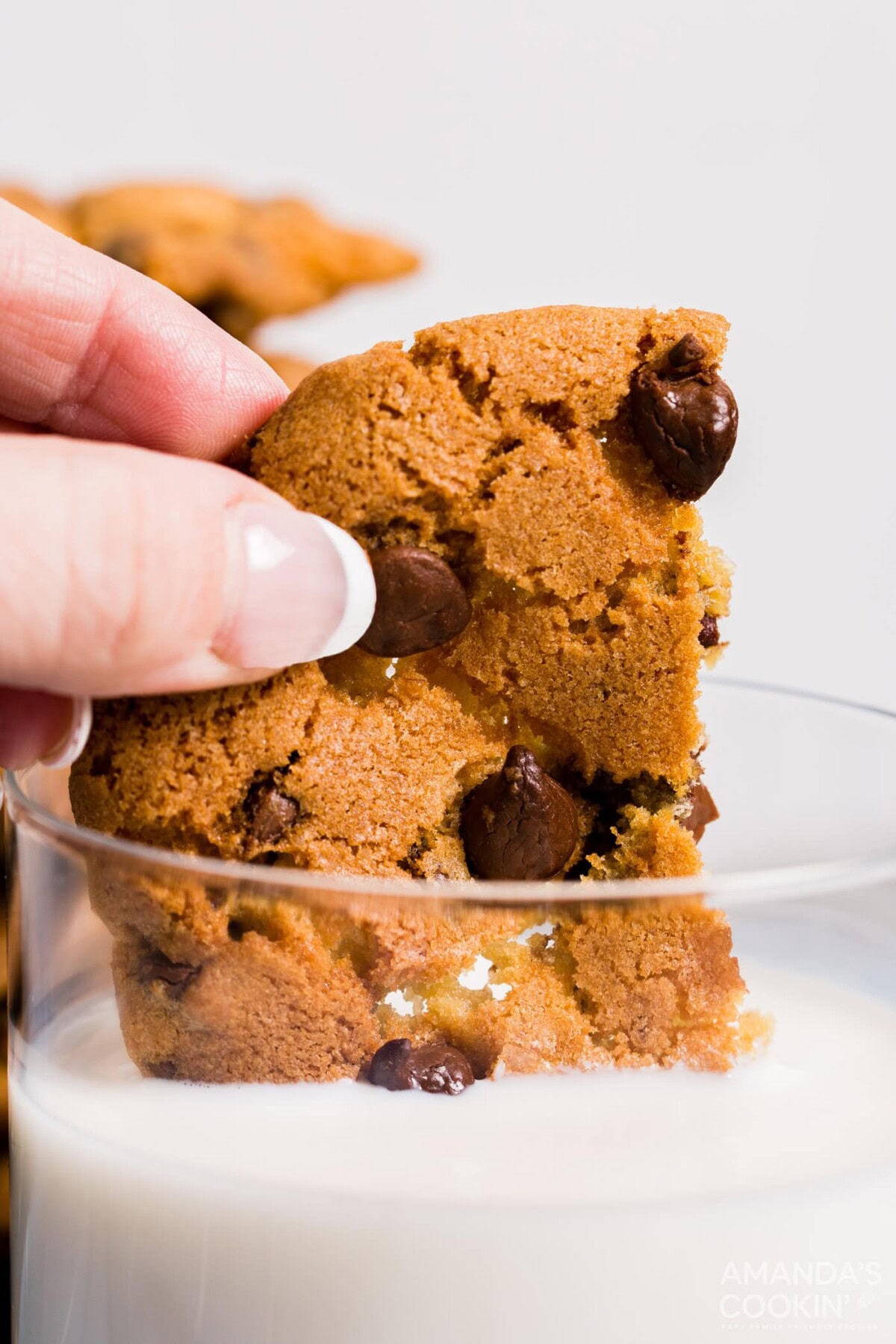 dipping air fryer chocolate chip cookie in milk