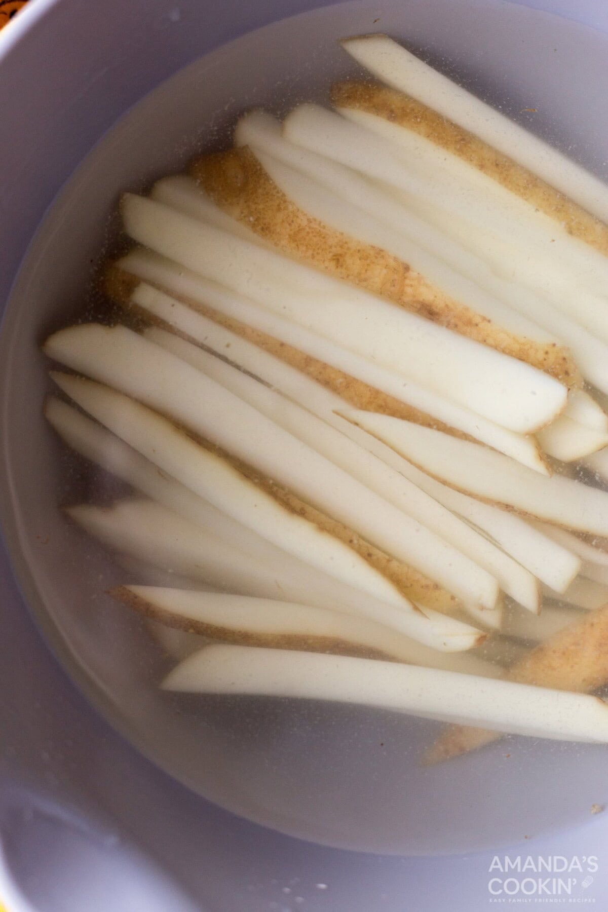 potato slices in a bowl of water