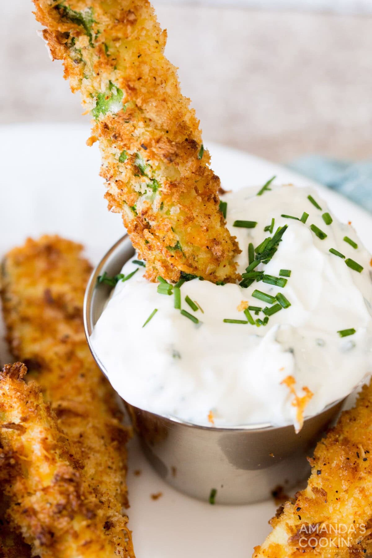 dipping an air fryer zucchini fry into sauce