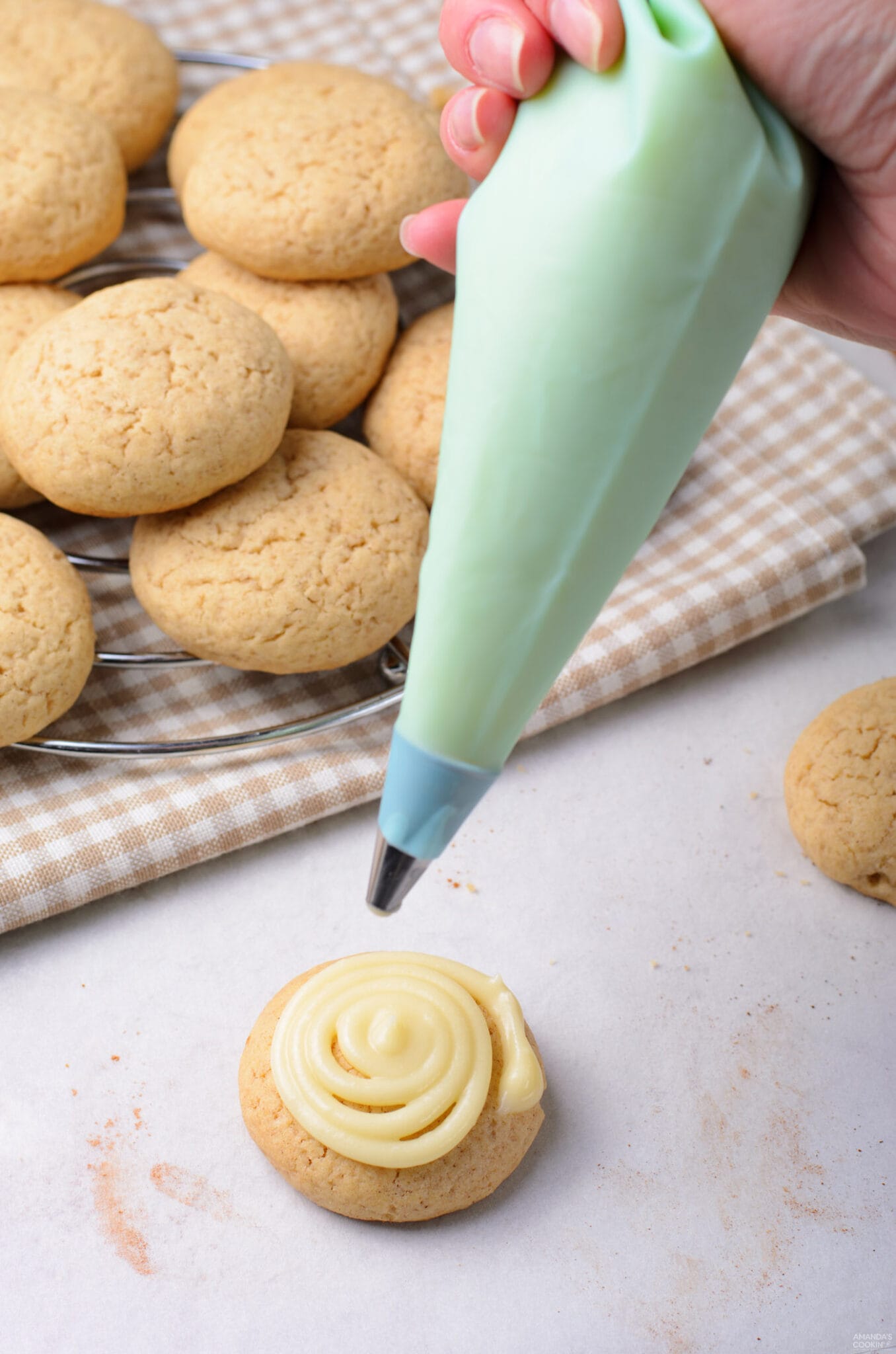 adding cream cheese frosting to cookie