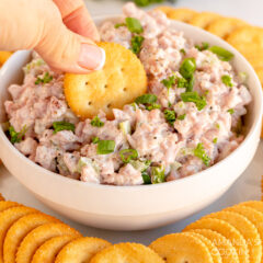 dipping cracker in a bowl of ham salad