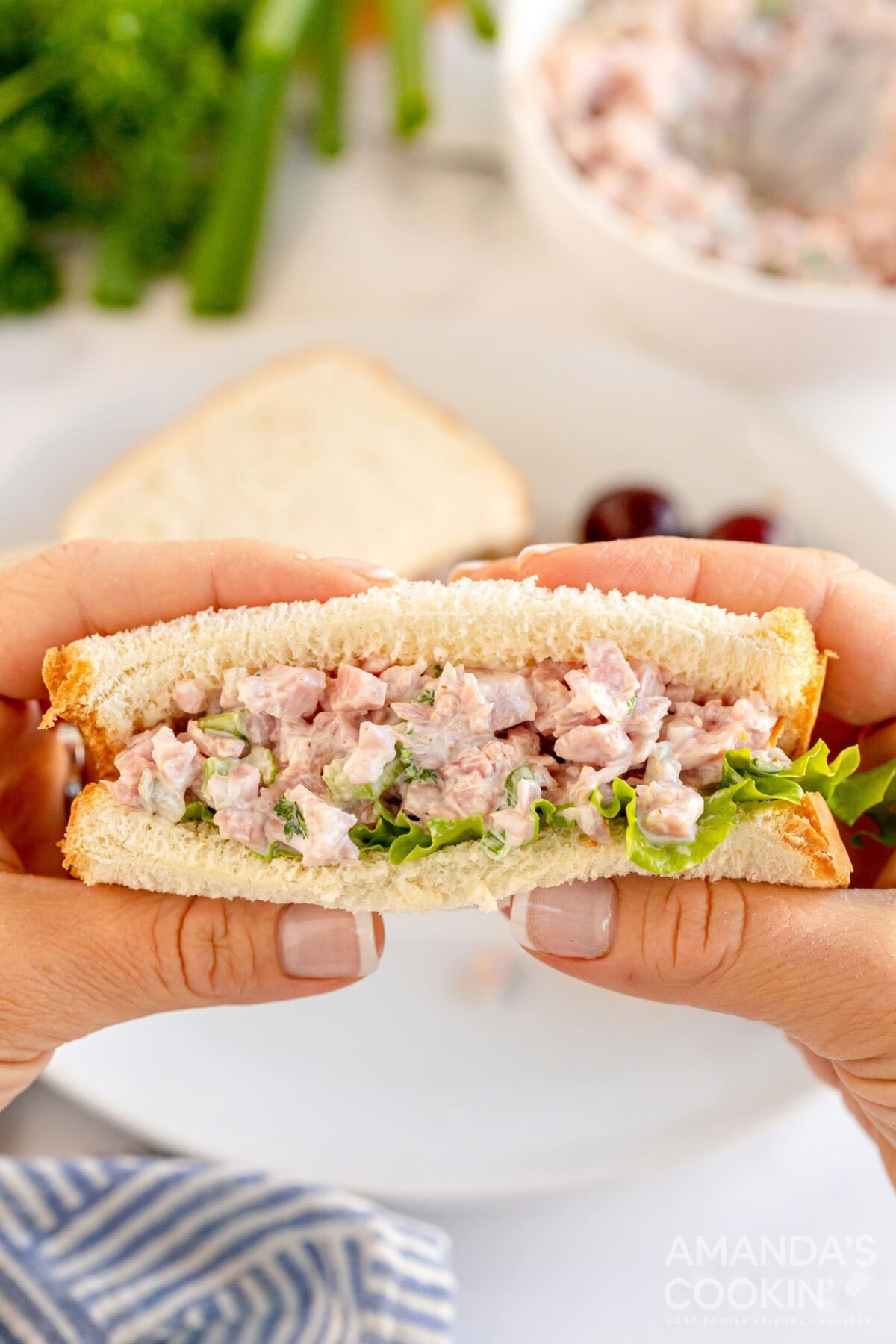 woman holding ham salad sandwich