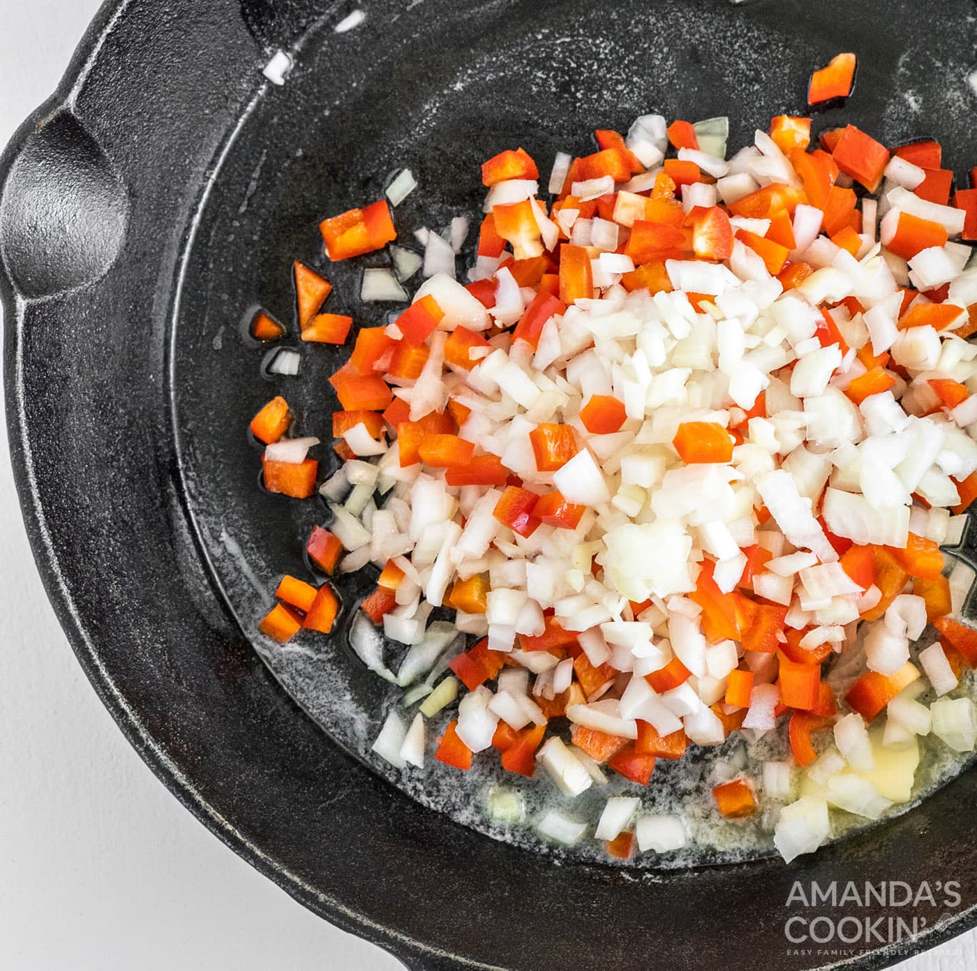 red bell pepper, onion, and butter in cast iron skillet