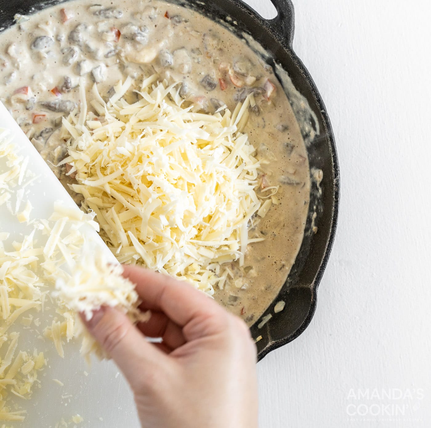 adding provolone to meat mixture in a skillet