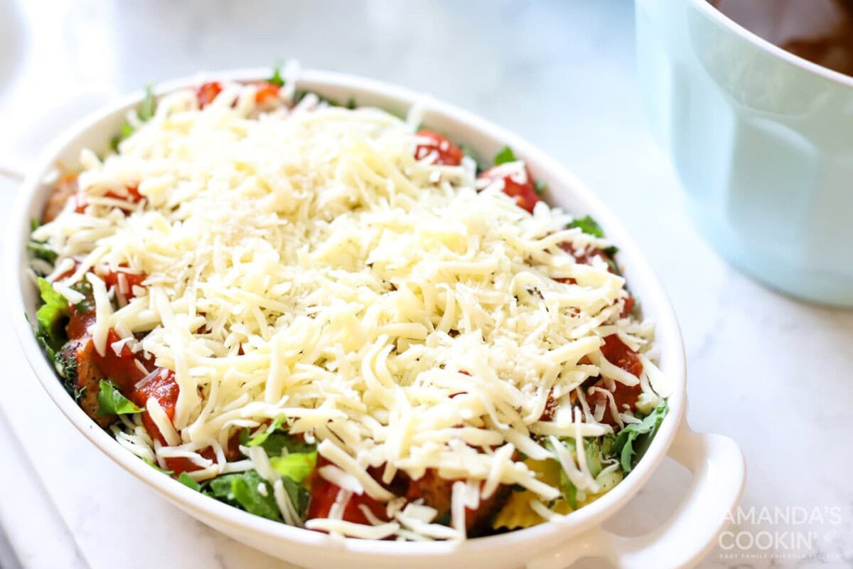 mozzarella cheese on top of spinach and sauce in a dish