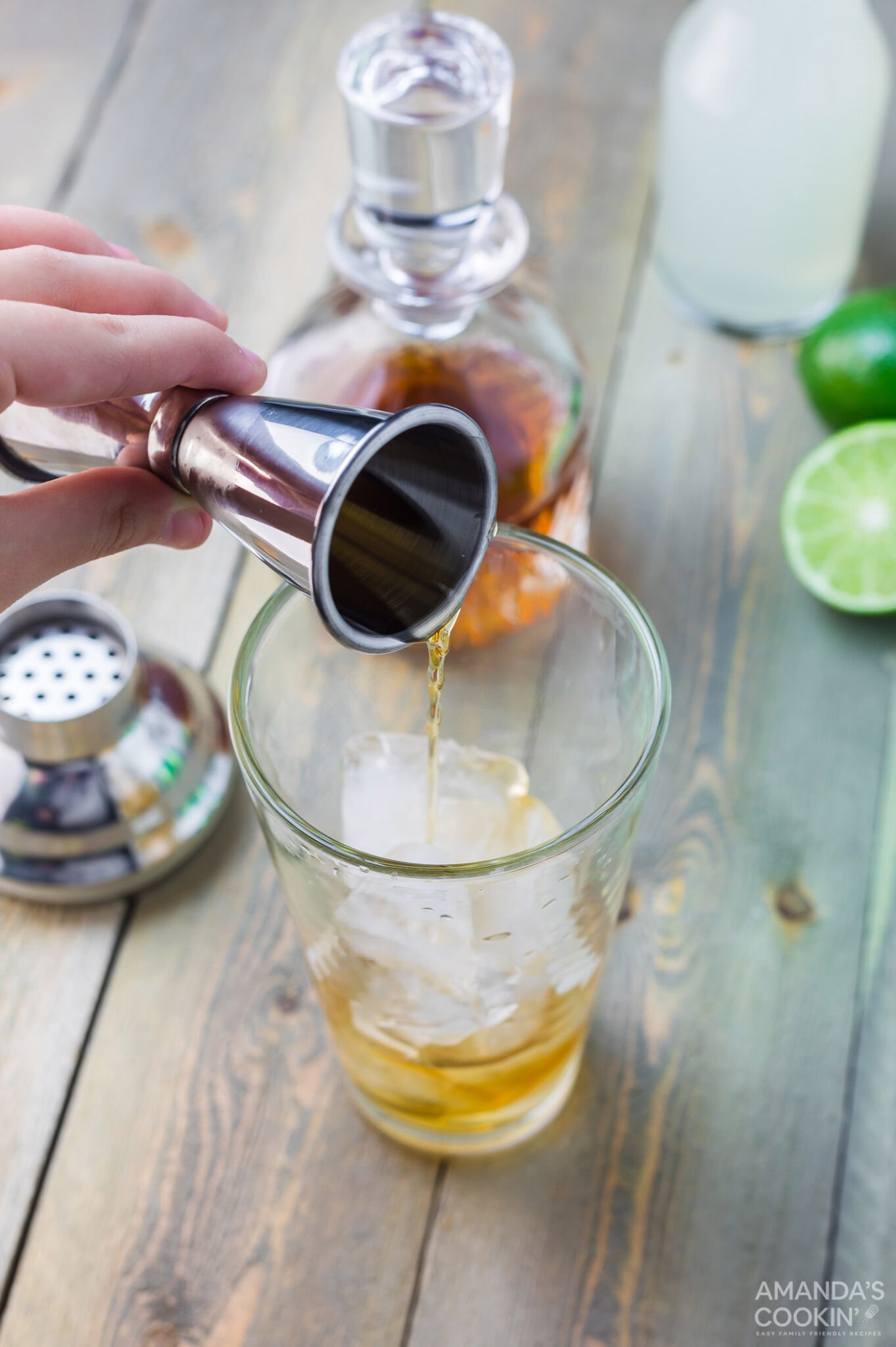 adding whiskey to a highball glass
