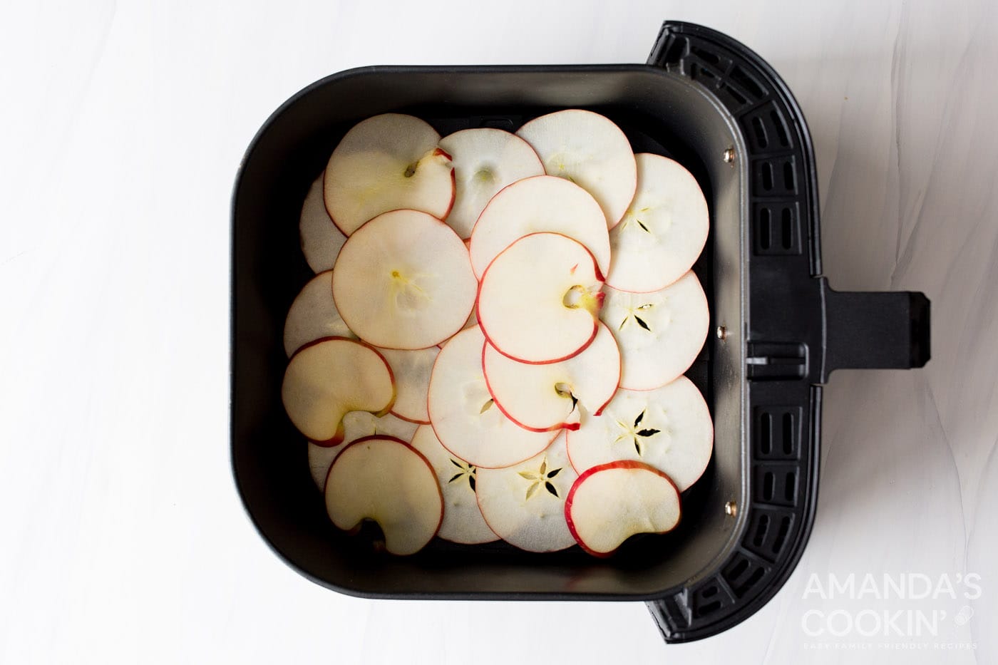 apple slices in an air fryer basket