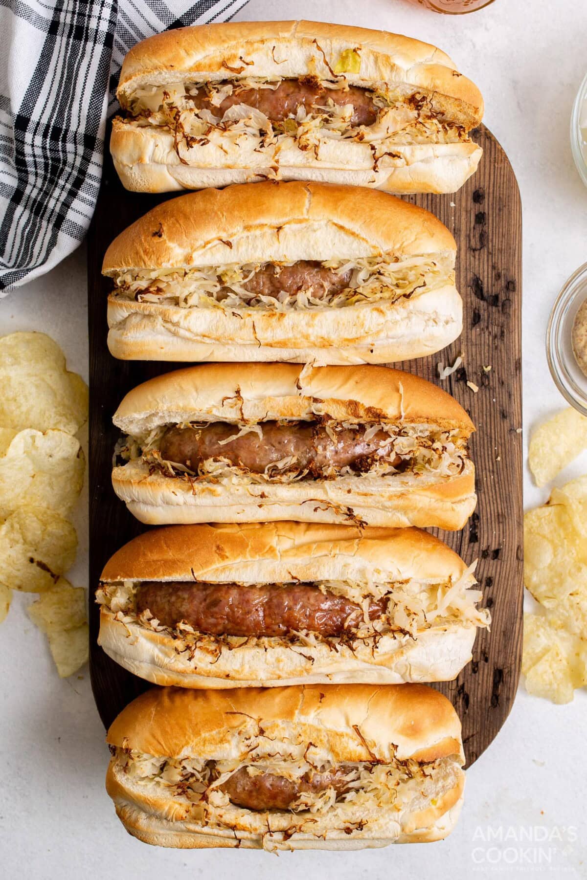 air fryer bratwurst in buns with sauerkraut on cutting board