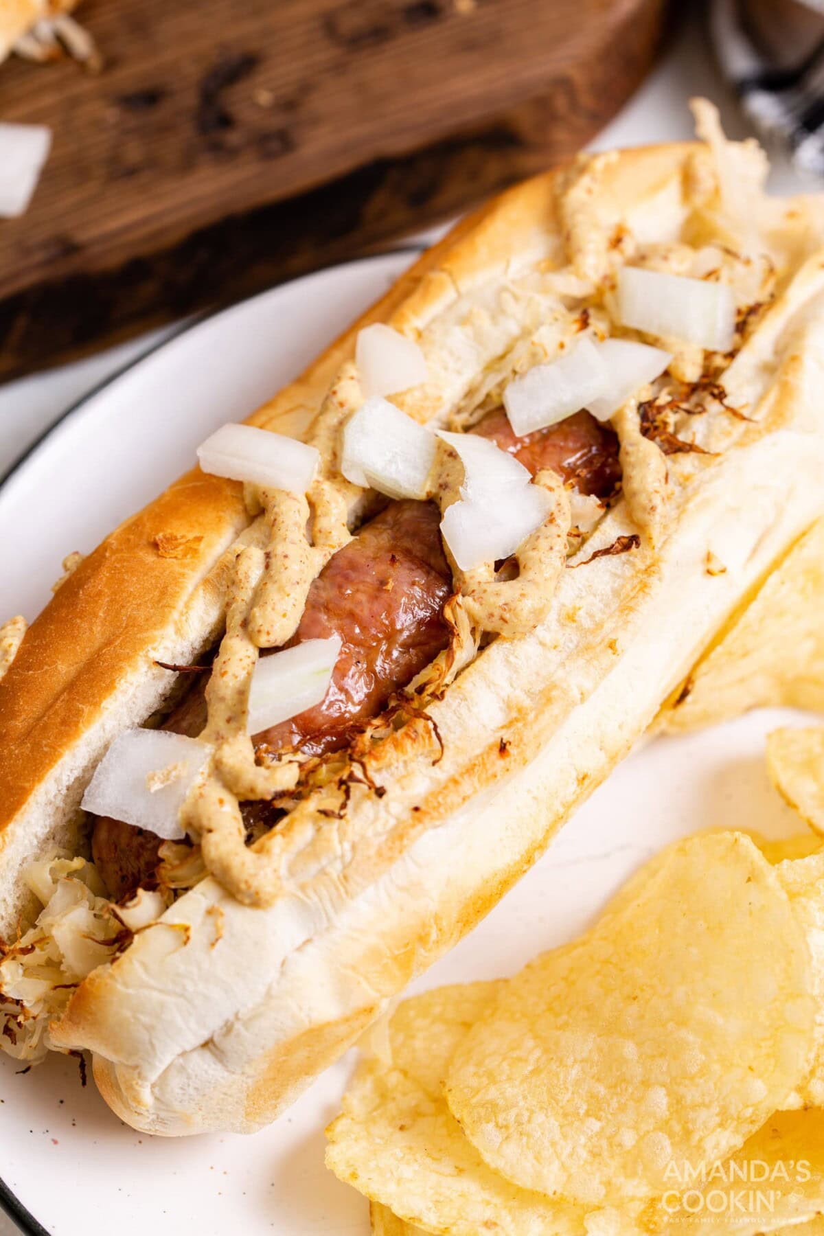 air fryer bratwurst on a bun with sauerkraut, mustard and onion