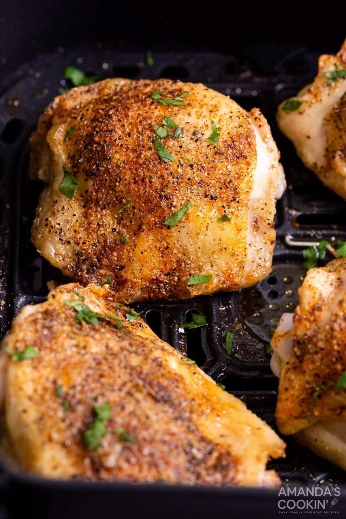 cooked chicken thighs in an air fryer basket
