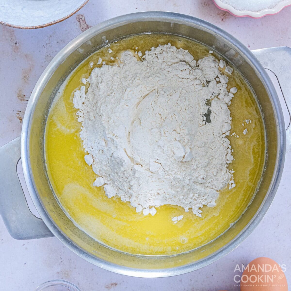adding flour to water, butter, sugar, and salt