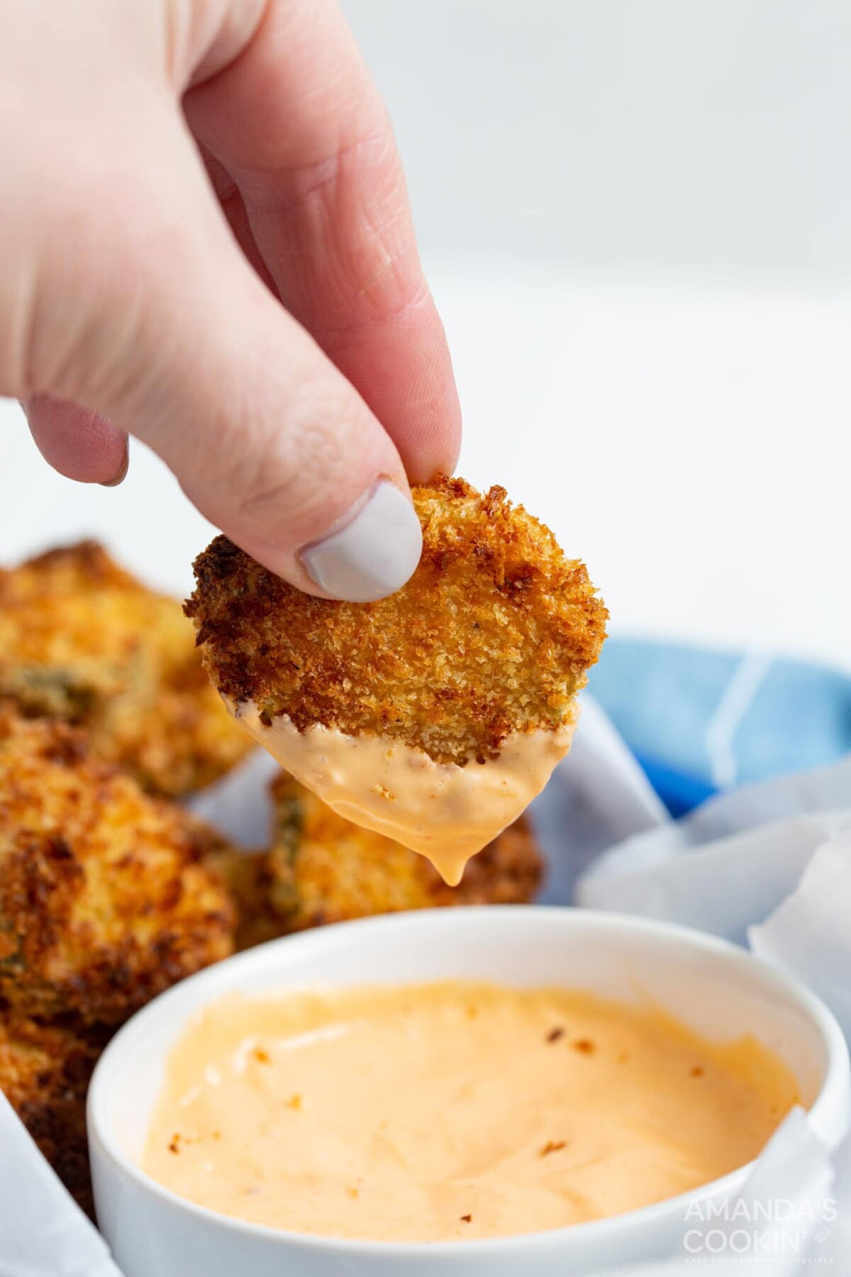 dipping an air fryer fried pickle in sauce