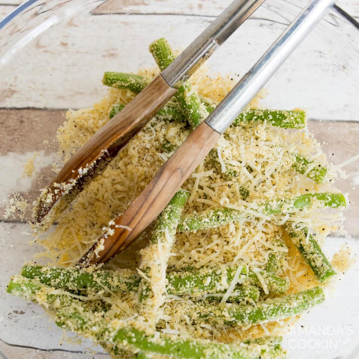 tossing green beans with almond flour, parmesan, egg, and seasonings