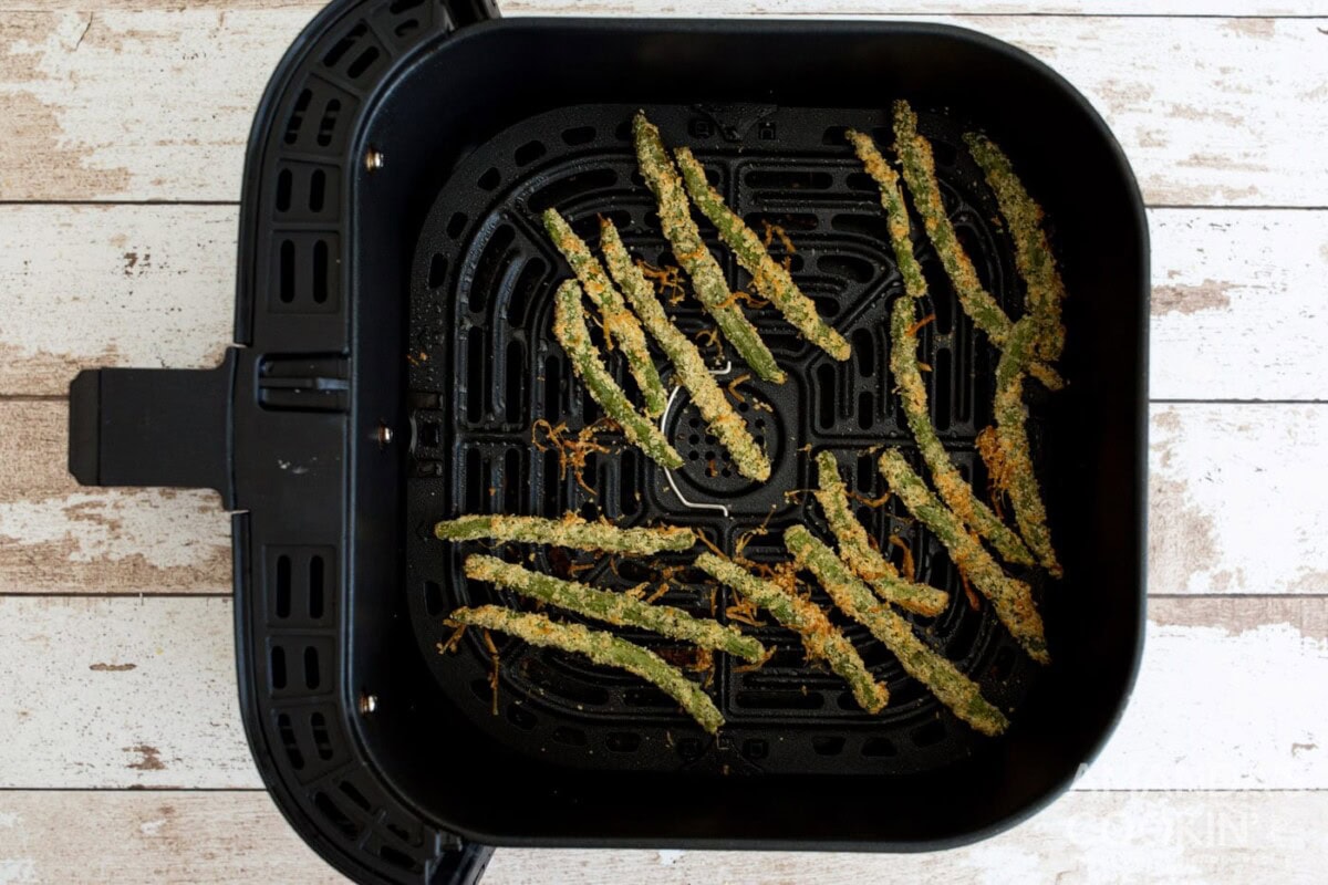 cooked green bean fries in air fryer basket