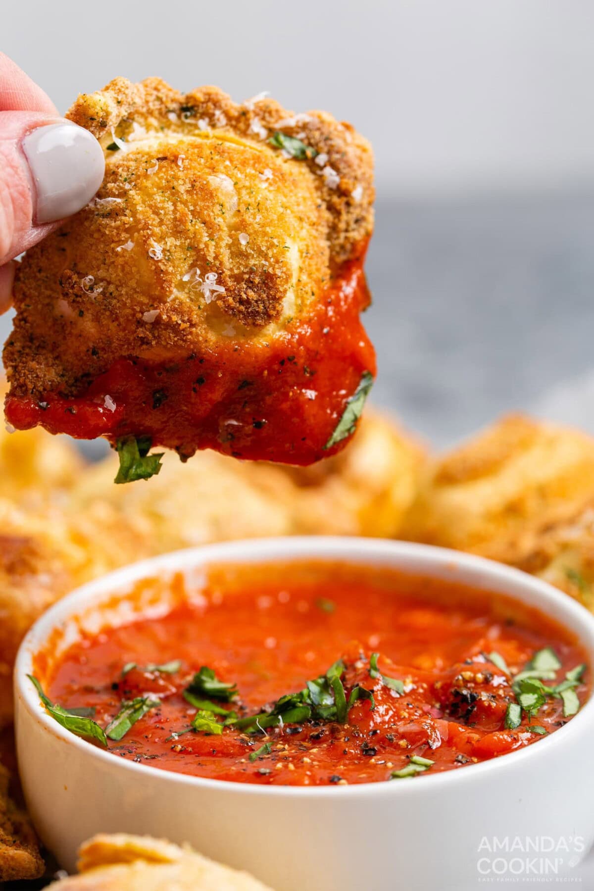 dipping air fryer ravioli in marinara