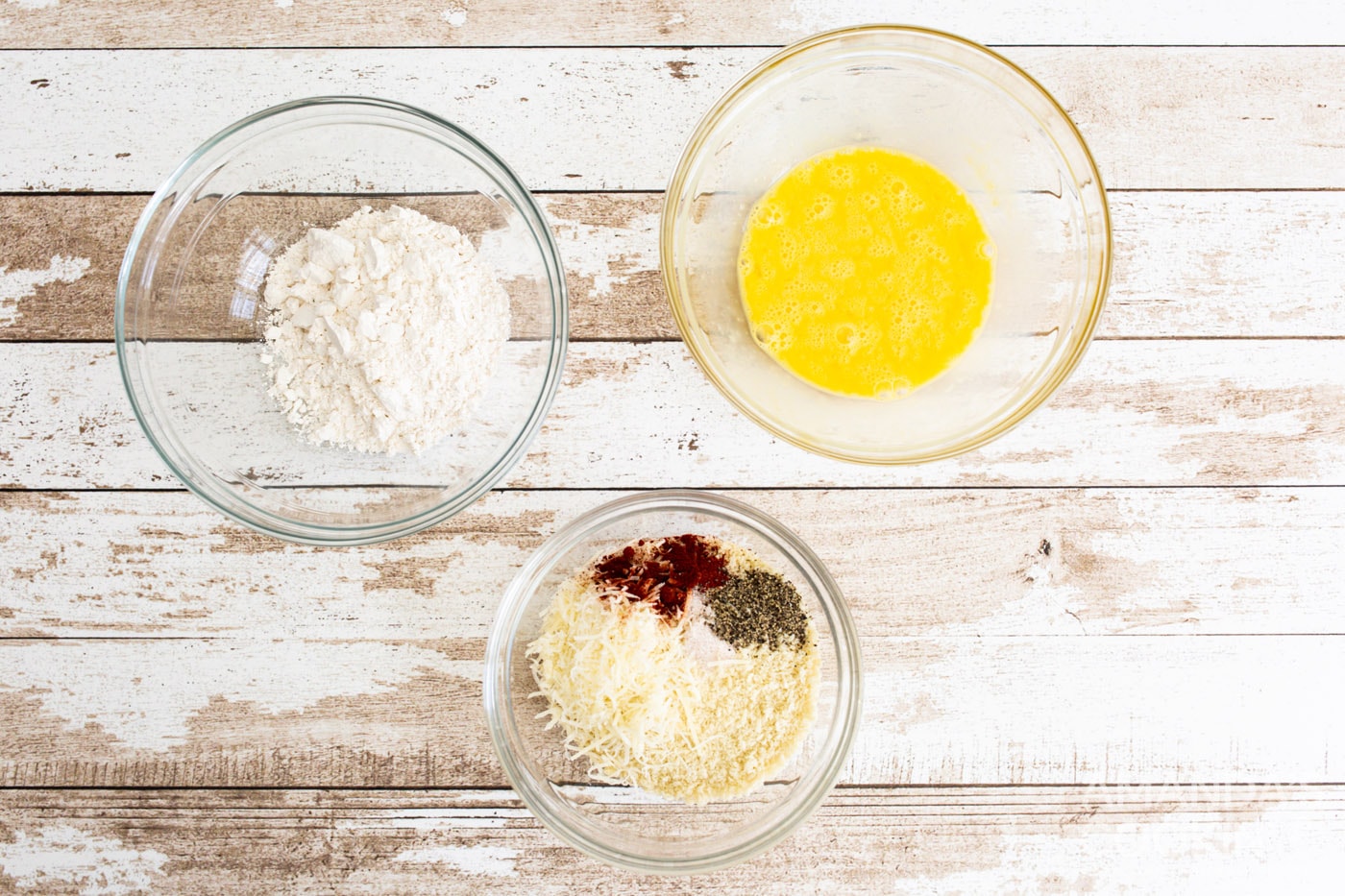 three bowls with egg, panko, and flour