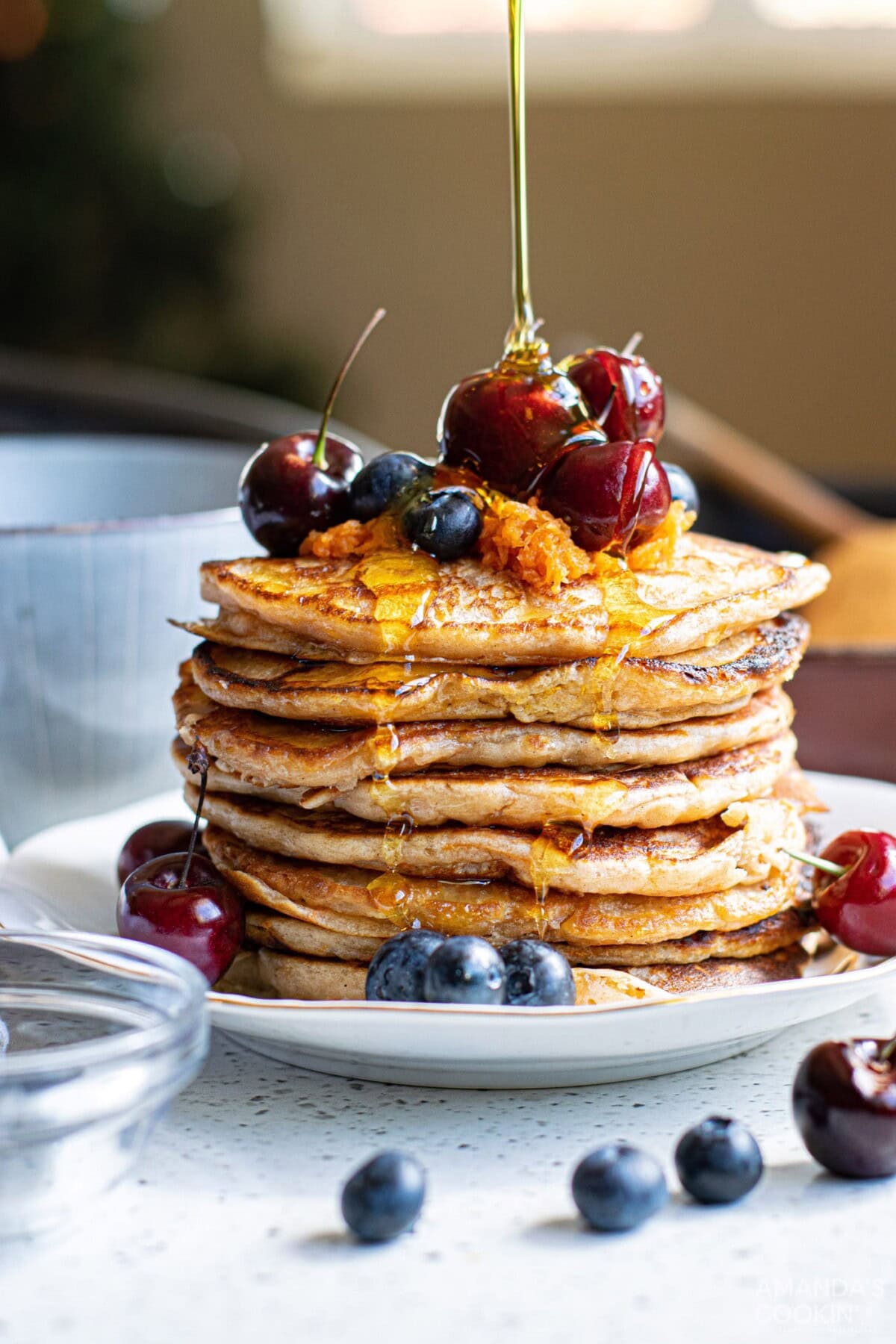 syrup being poured onto carrot cake pancakes