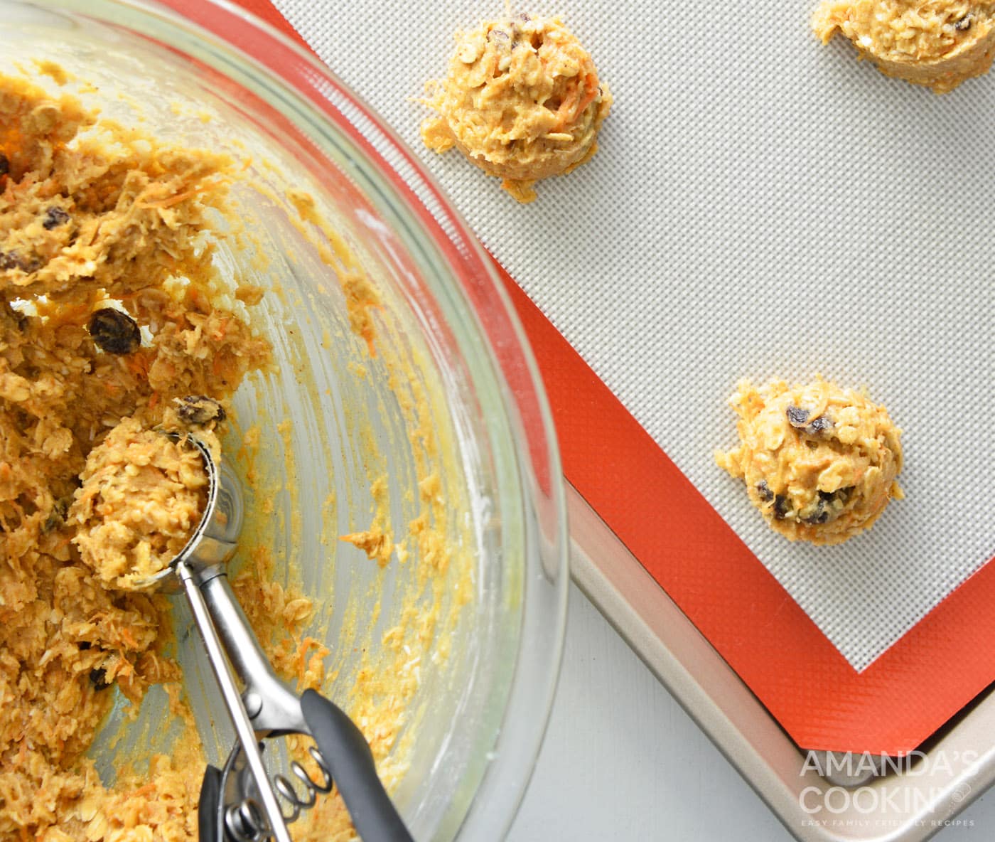 using a cookie scoop to scoop dough into balls on a baking sheet