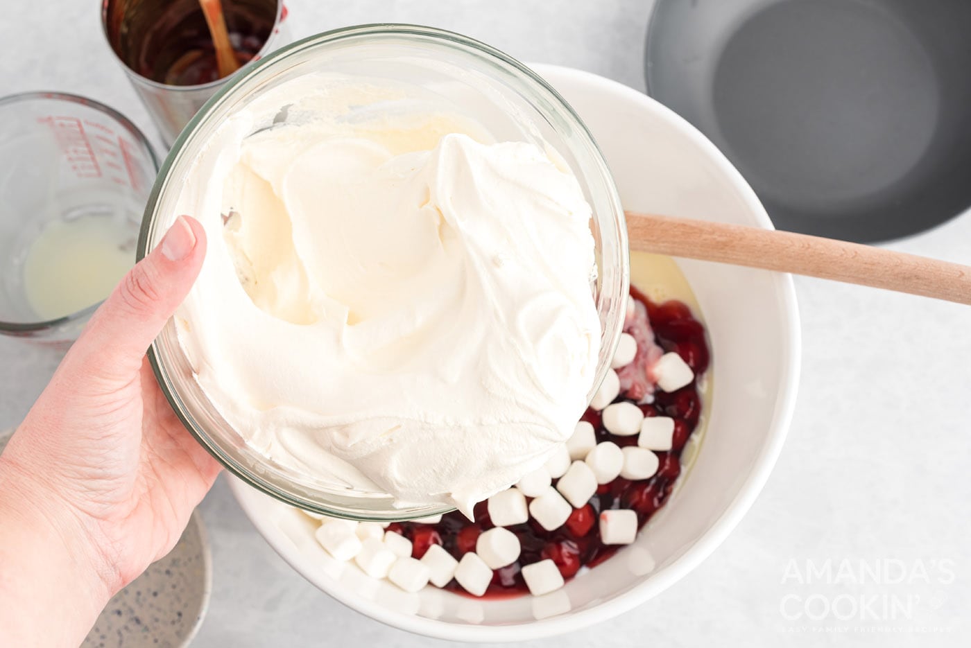 adding cool whip to mixture in bowl