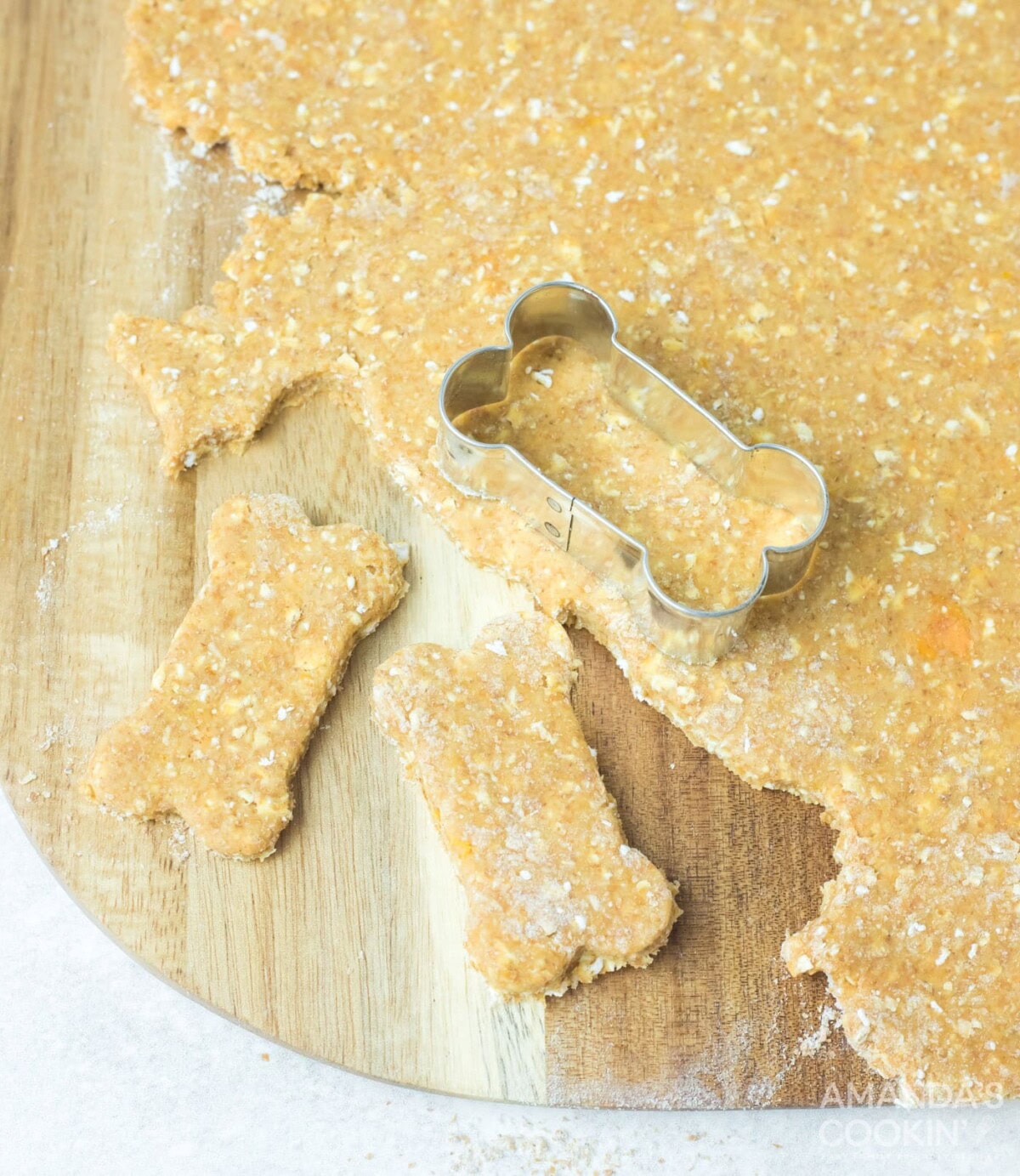 bone shaped cookie cutter cutting dough
