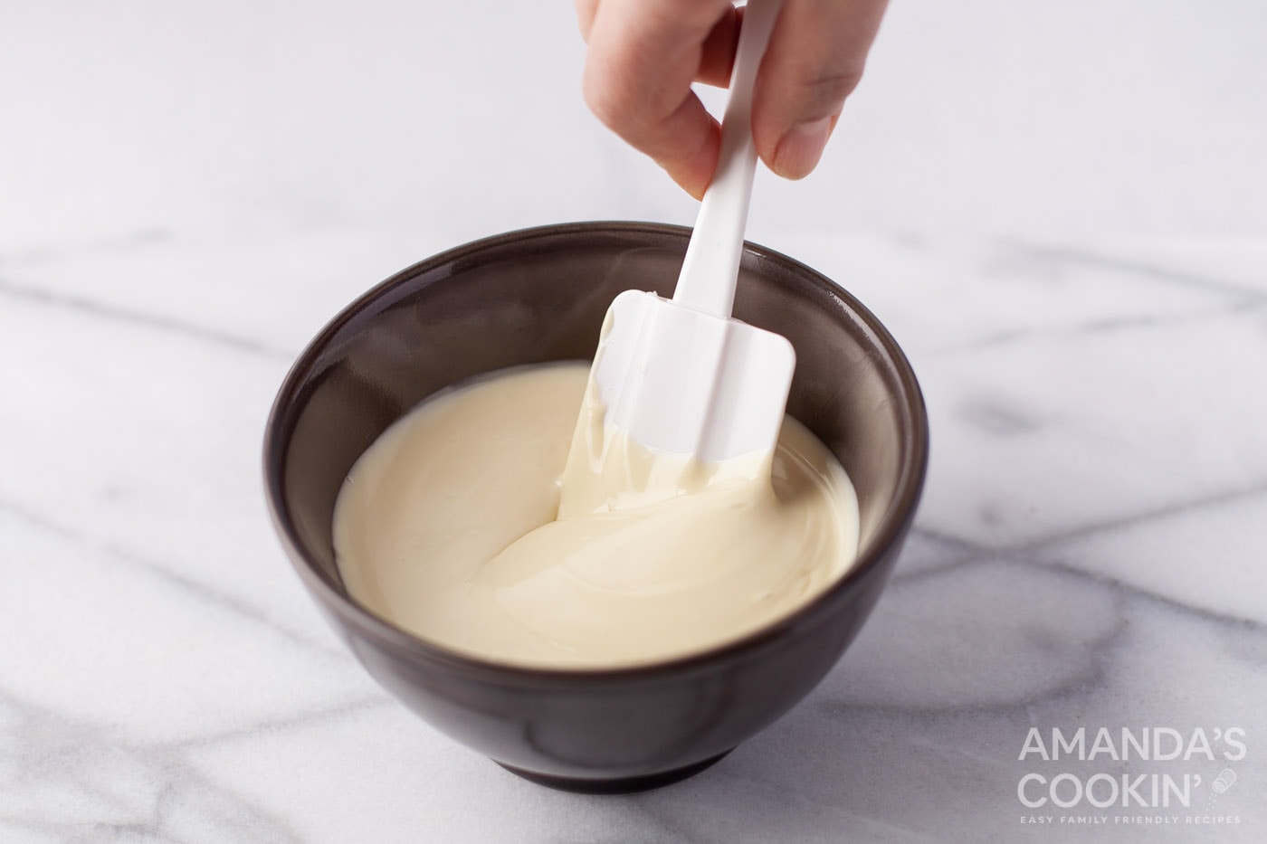 stirring white chocolate in a bowl