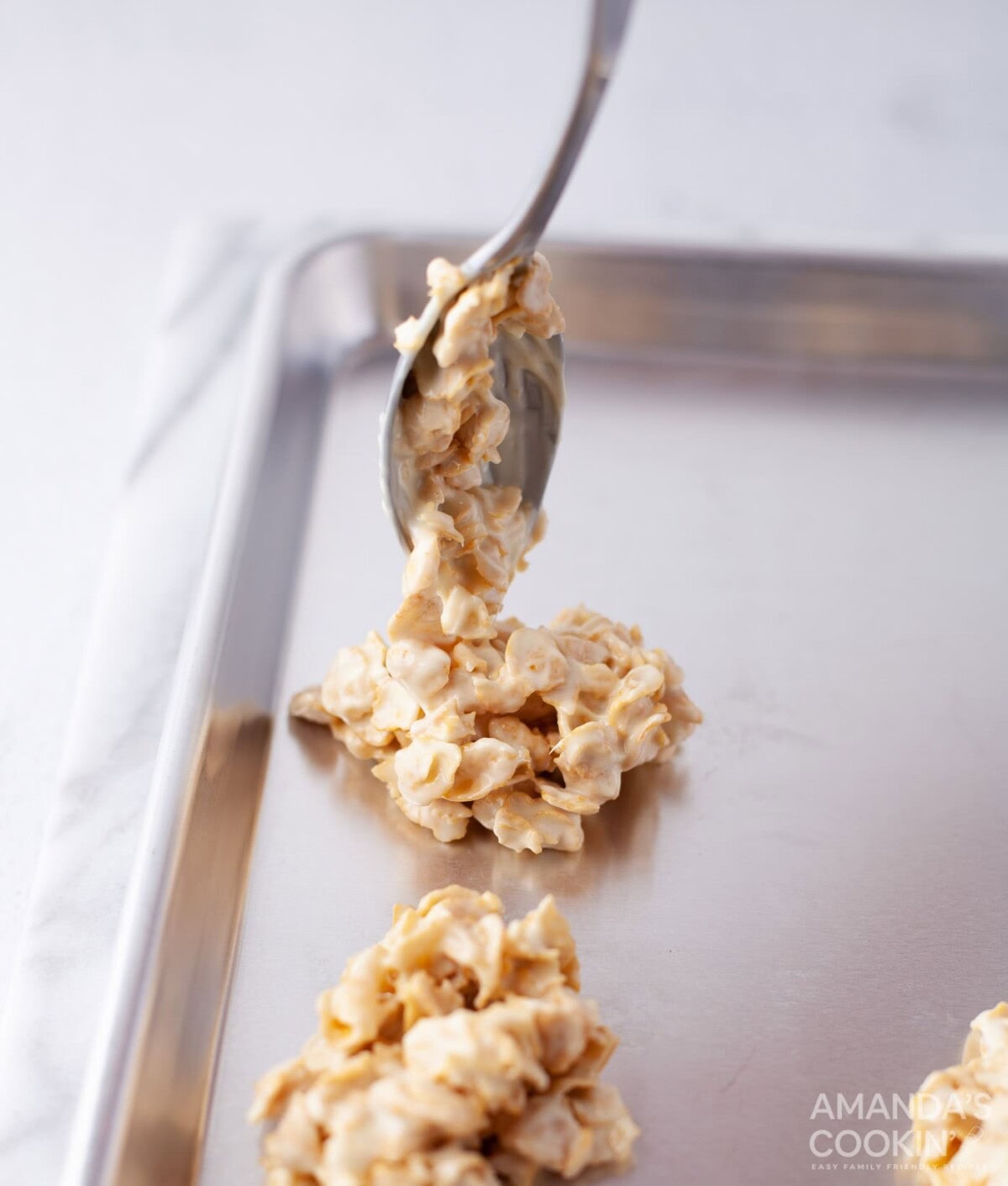 spooning cornflake cookies onto baking sheet
