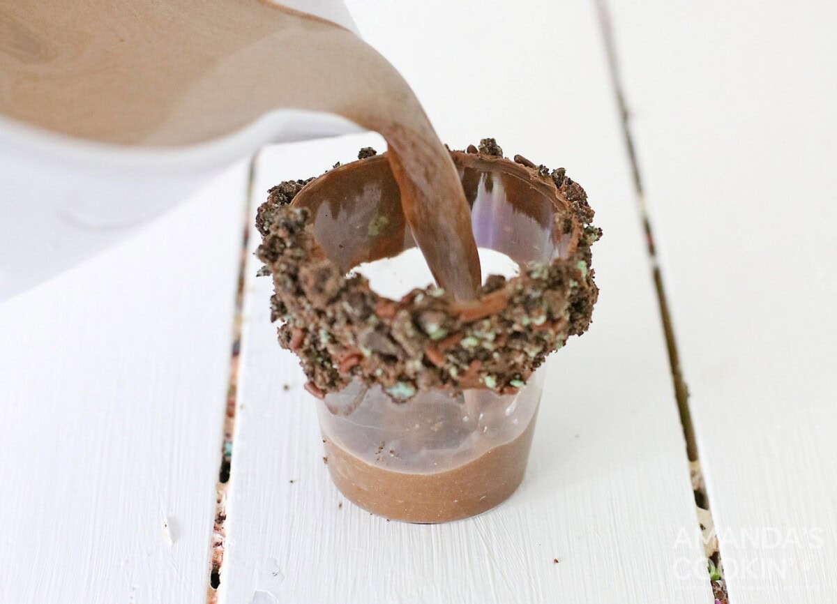 pouring chocolate alcohol into shot glass