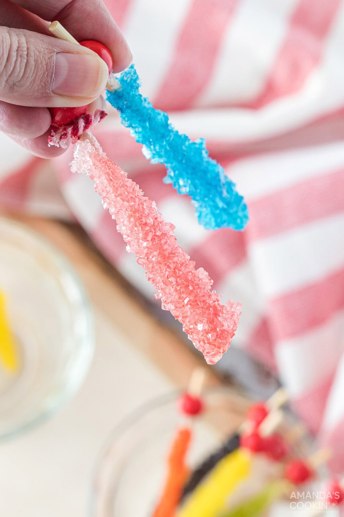 holding 2 pieces of rock candy
