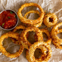 Air Fryer Onion Rings on parchment with dish of ketchup