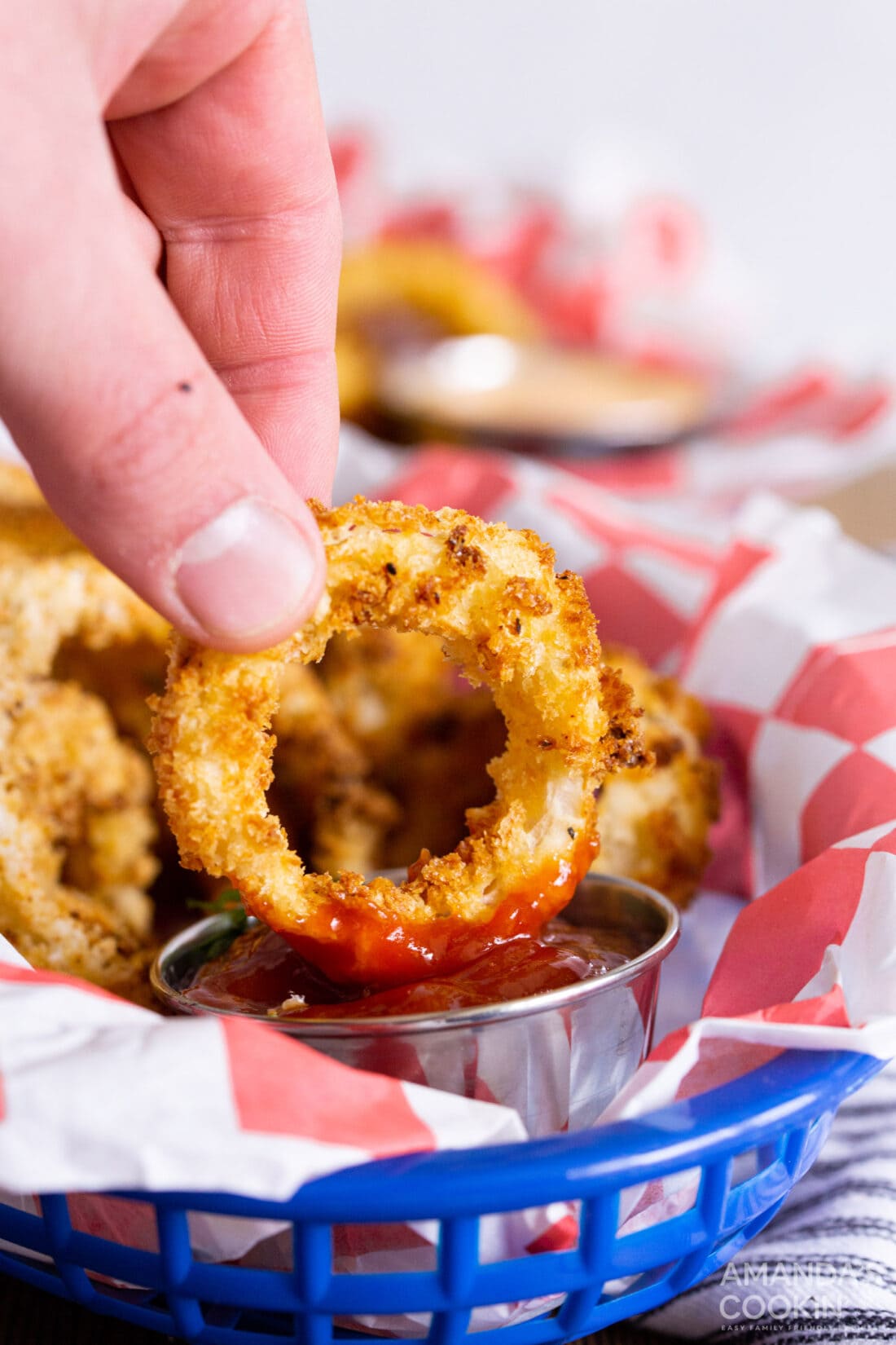 Dipping an onion ring in ketchup
