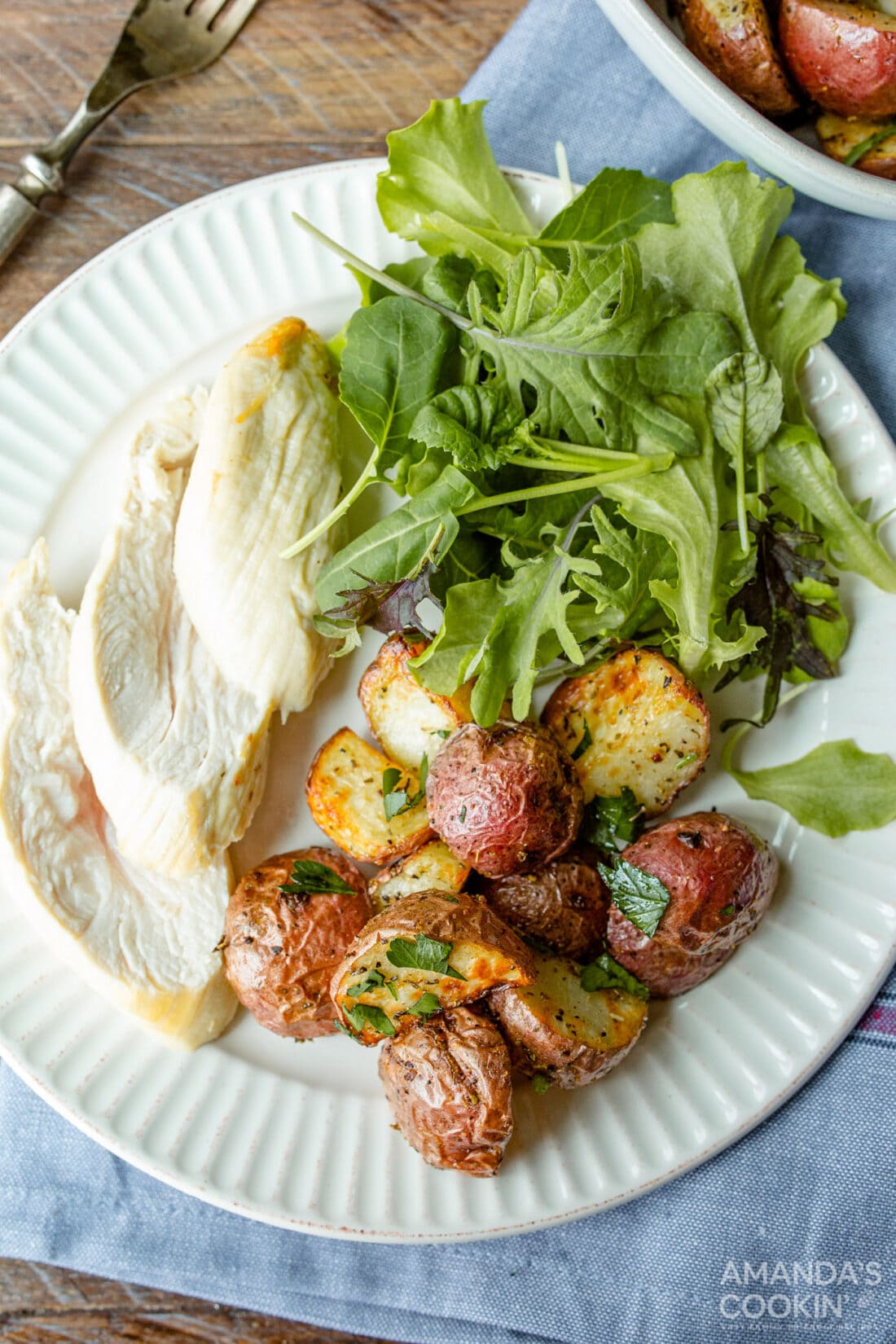 Air Fryer Roasted Potatoes and chicken on a plate with salad greens