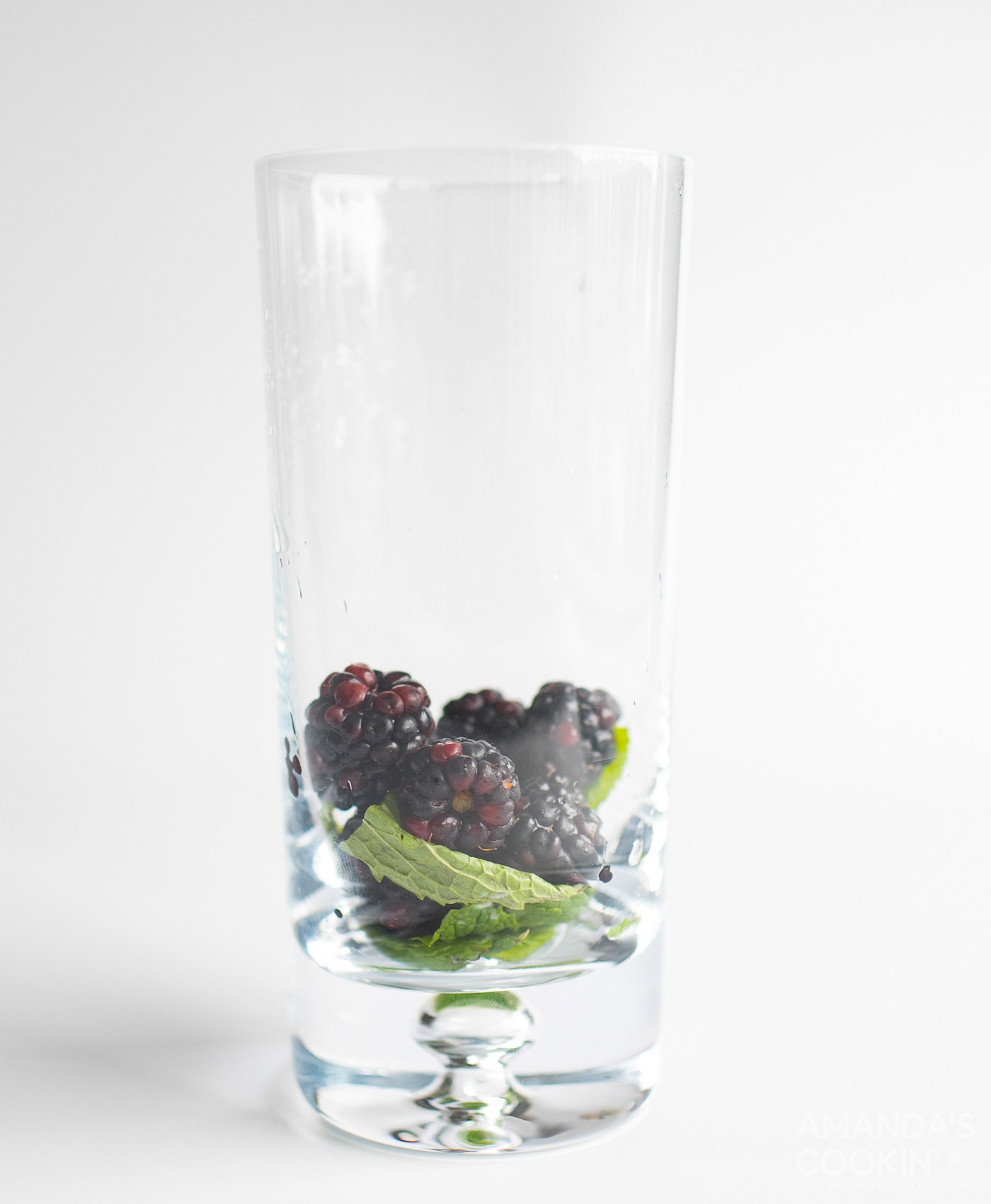 blackberries and mint leaves in a tall glass