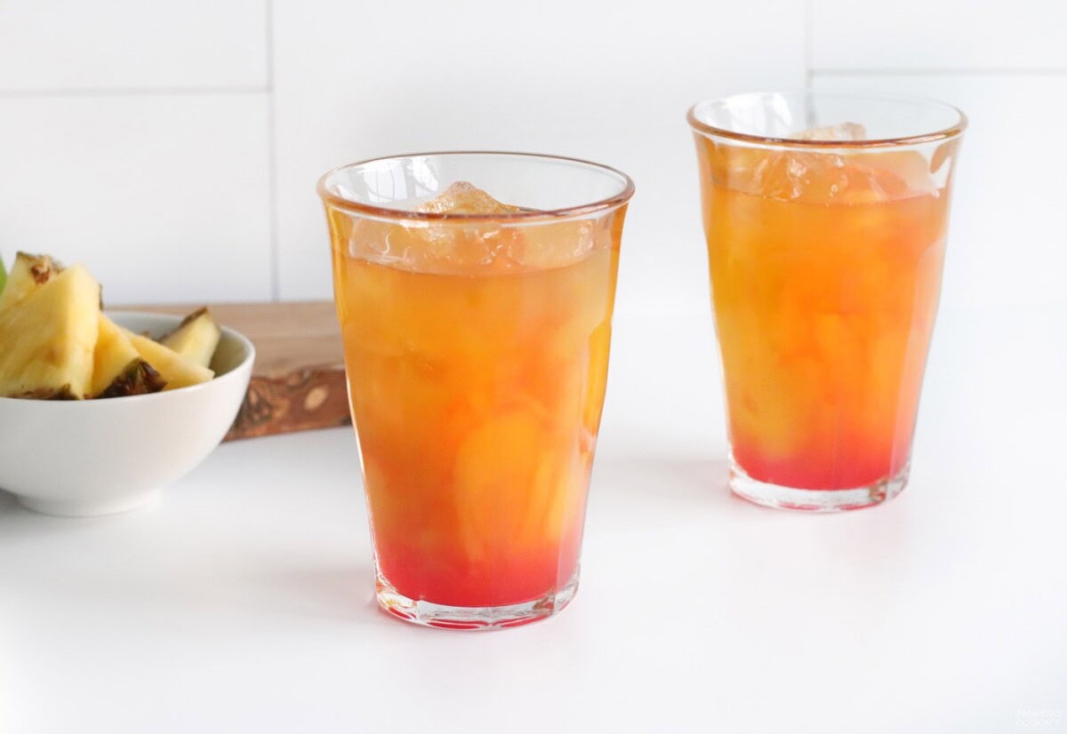 grenadine in a glass of pineapple juice, mango juice, and rum
