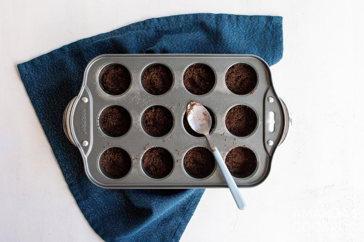 spoon in graham cracker crust into mini muffin pan
