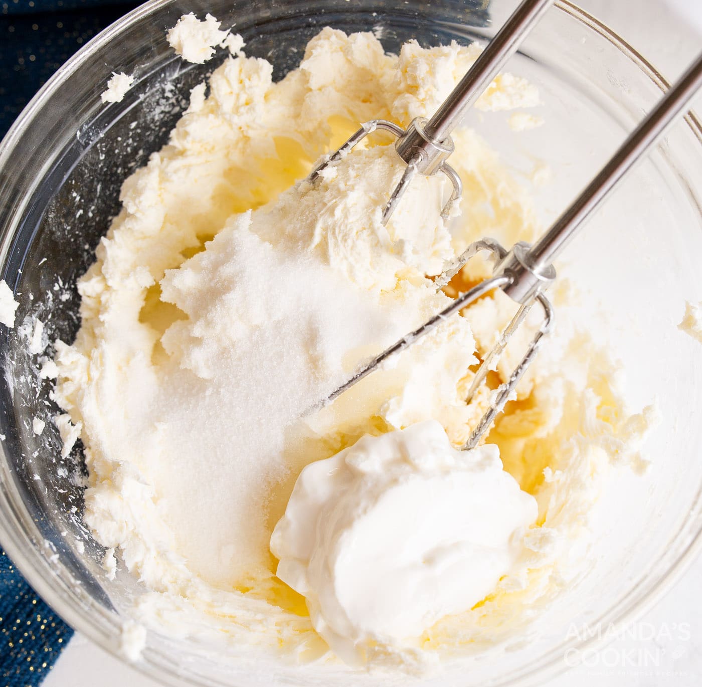 beating cheesecake ingredients with a hand mixer