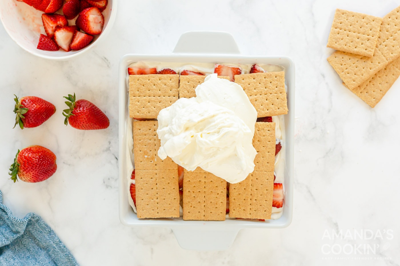 whipped cream on top of graham crackers and strawberries