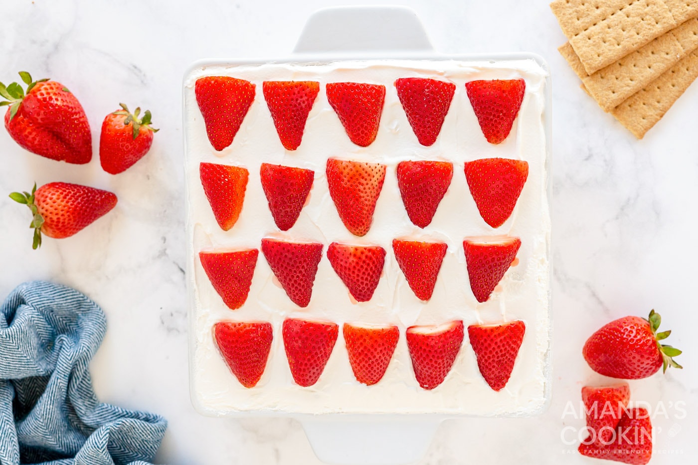 overhead photo of sliced strawberries on top of whipped cream