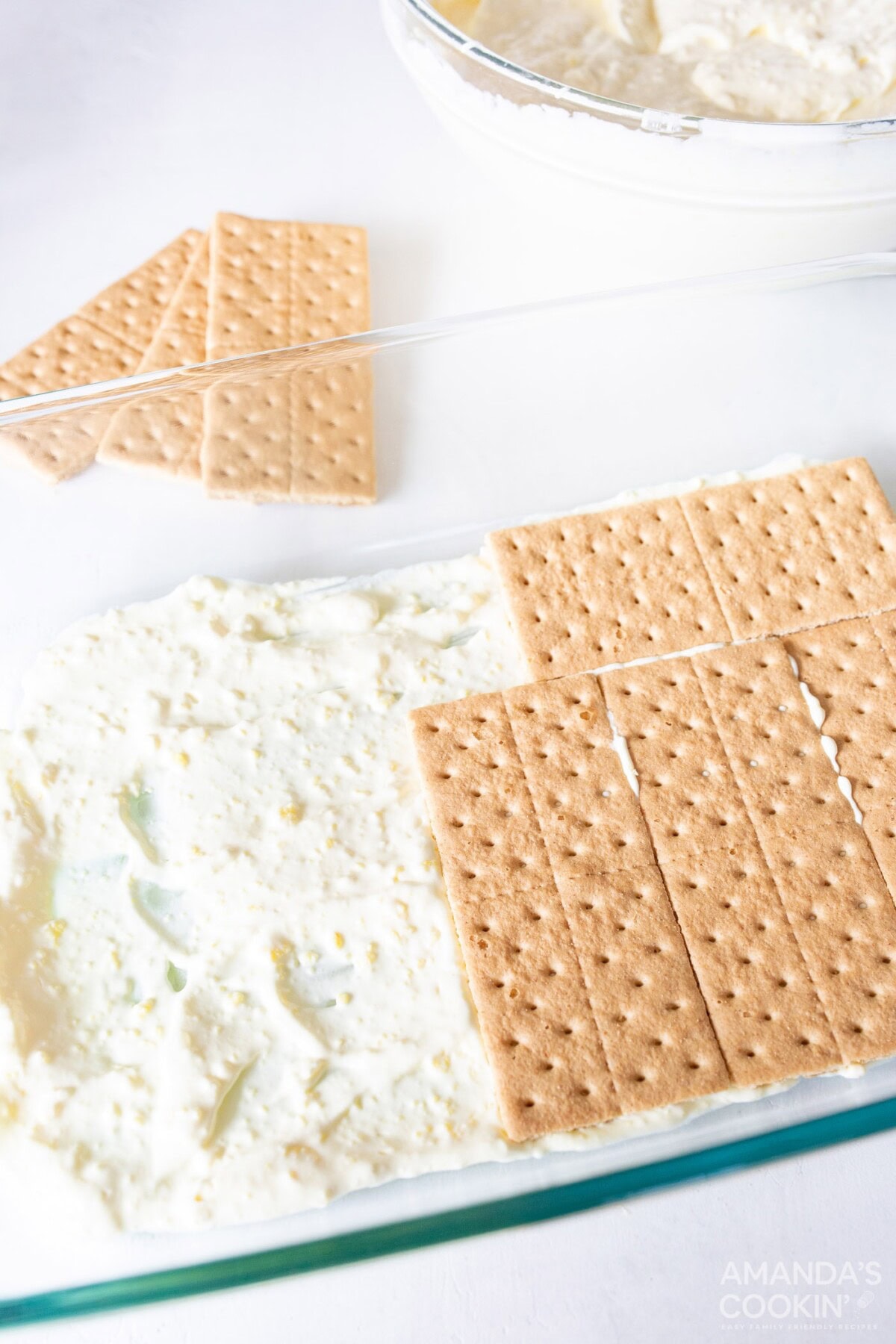 adding graham crackers to 13x9 baking dish with lemon pudding mix