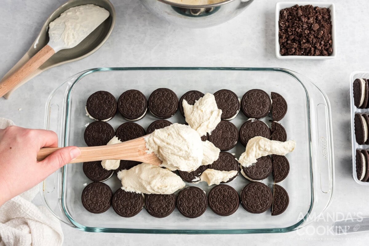 layer of oreos on bottom of a baking dish with scooped whipped topping
