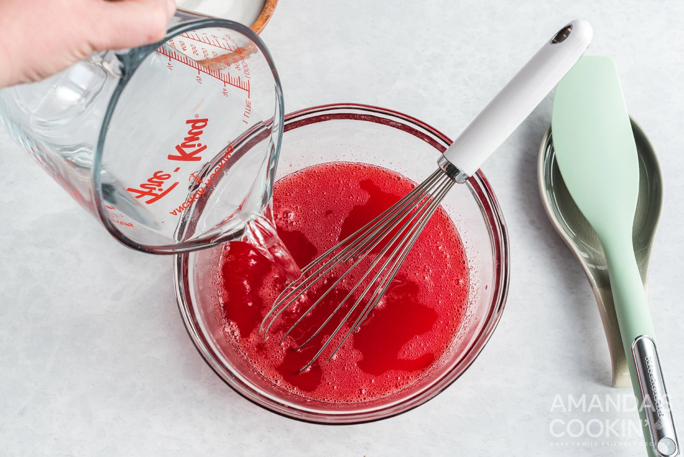 adding cold water to strawberry jello