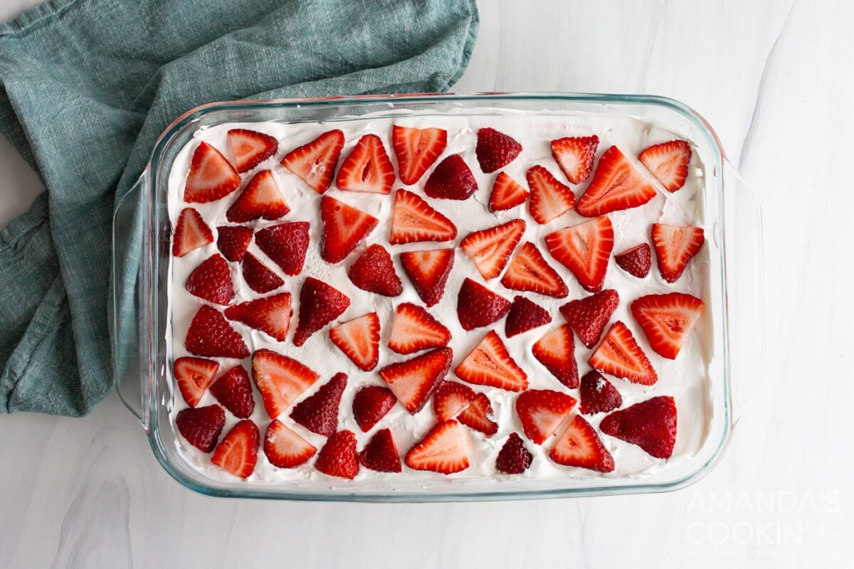 sliced strawberries on top of dessert in a baking dish