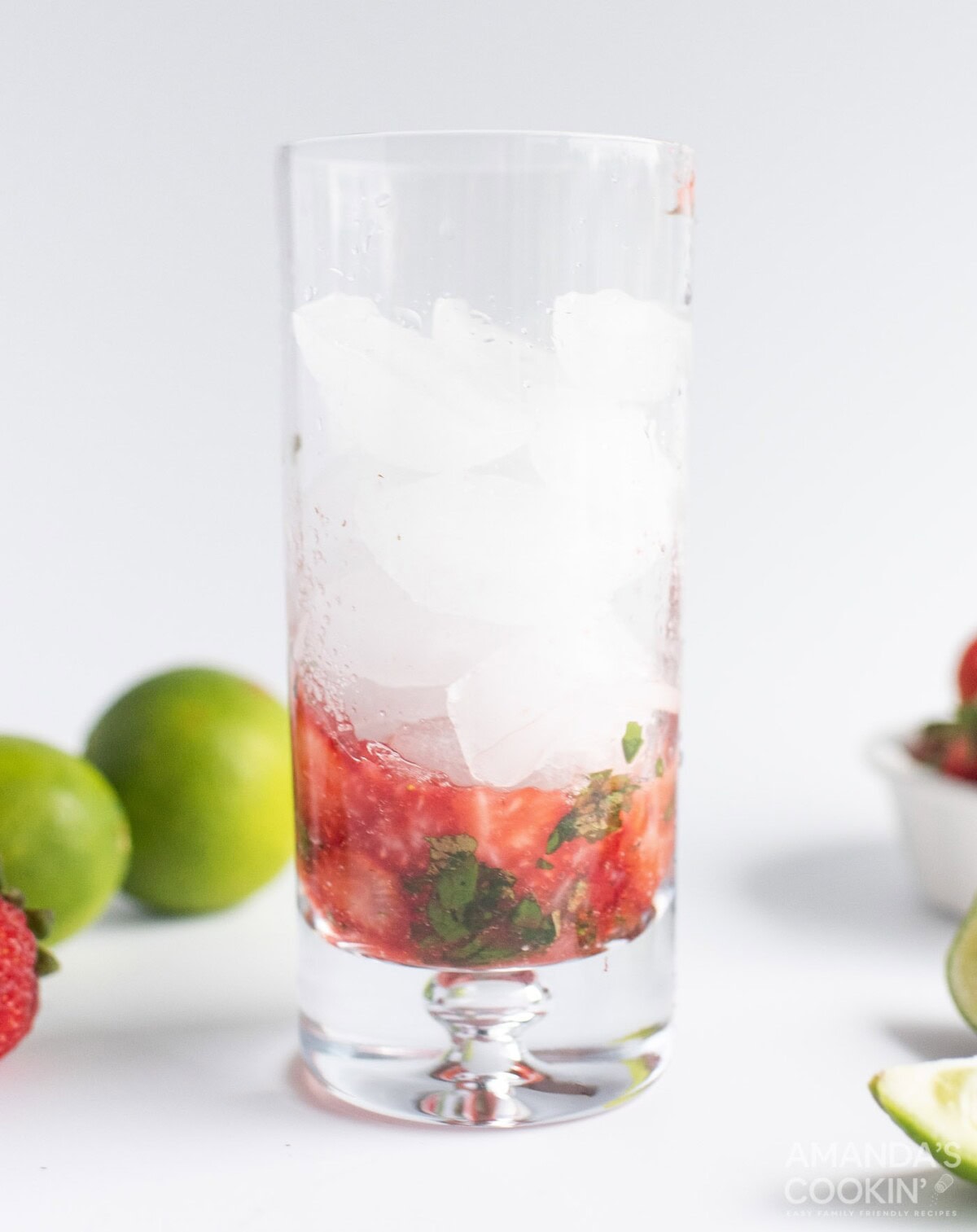 muddled strawberries and mint in a glass with ice