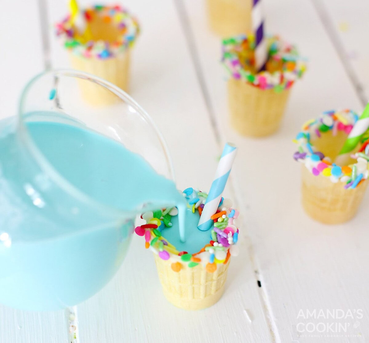 pouring blue rum chata into ice cream cone shot glasses
