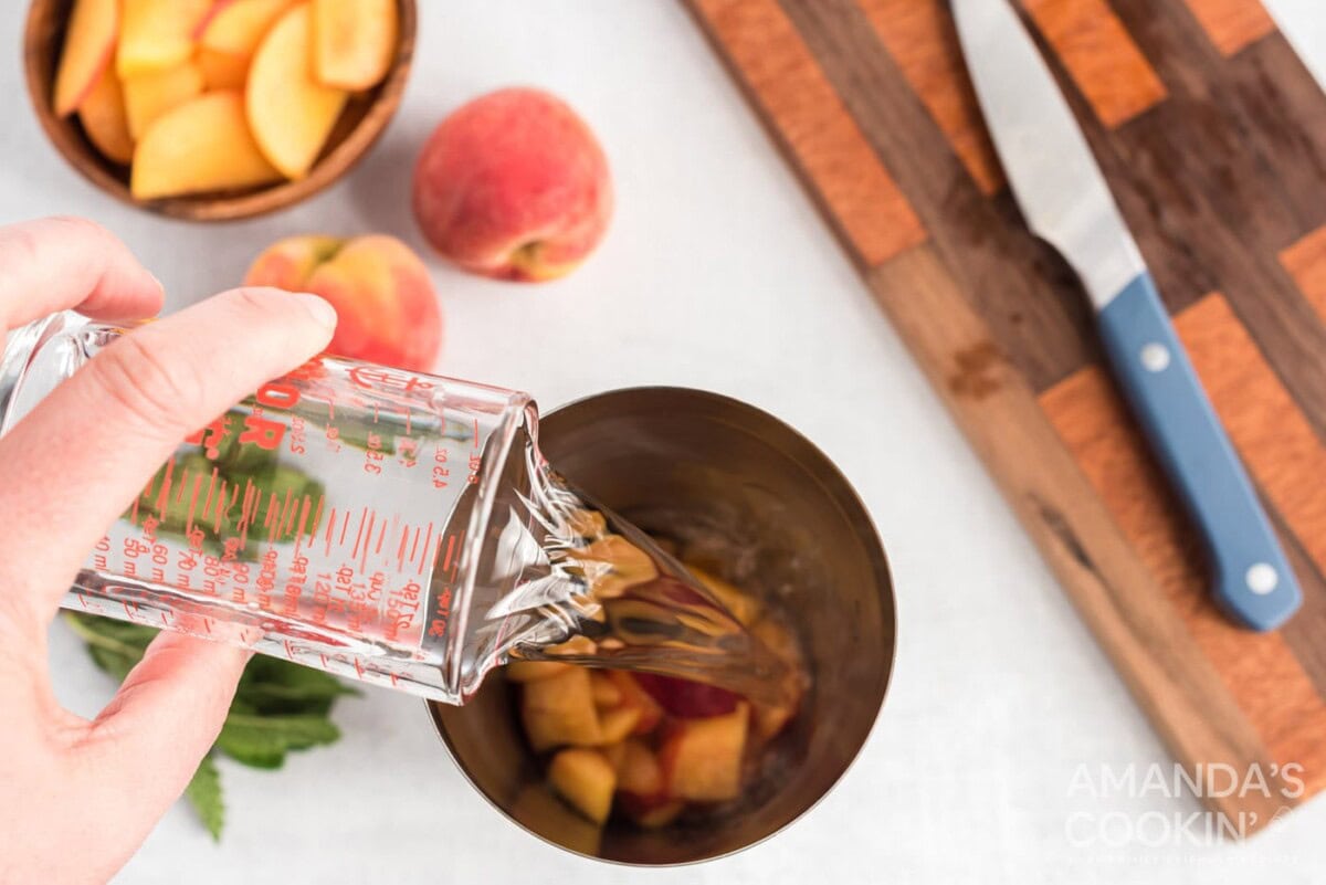 adding rum to chopped peaches