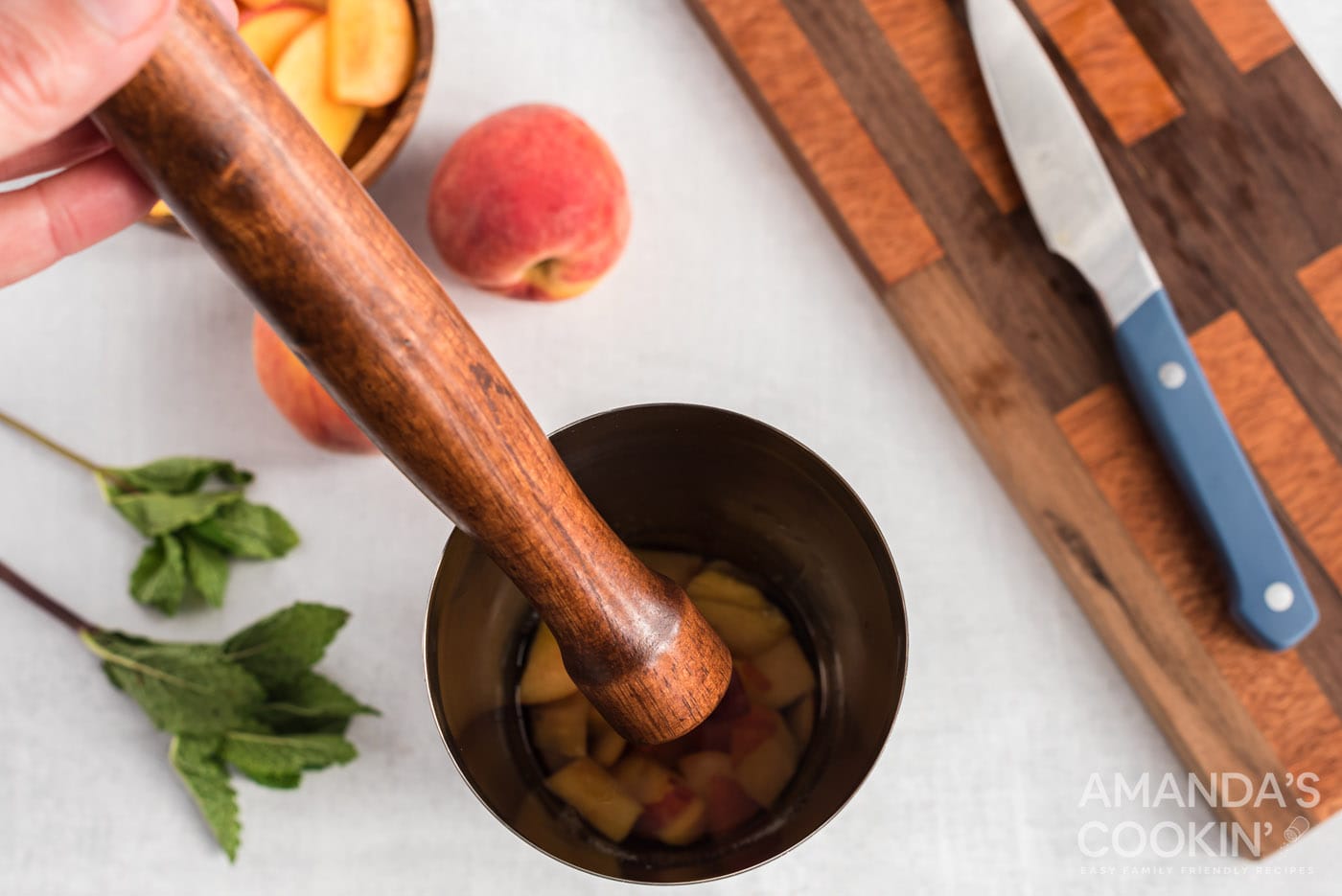 muddling peaches with rum and sugar