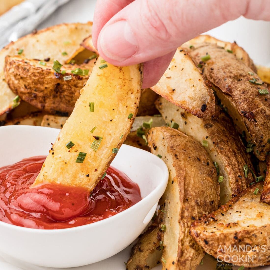 dipping potato wedge in ketchup